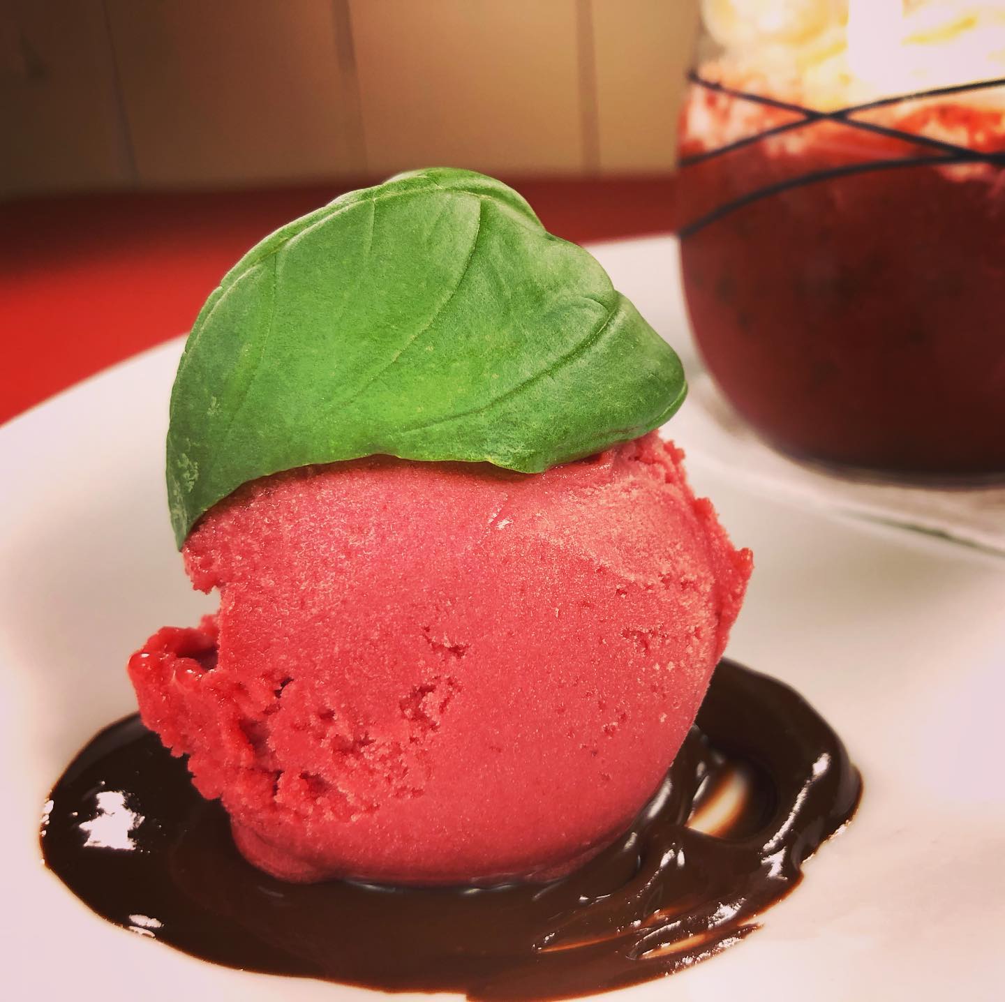 Boule de glace sur lit de chocolat chaud fondu au beurre et sa coiffe basilic