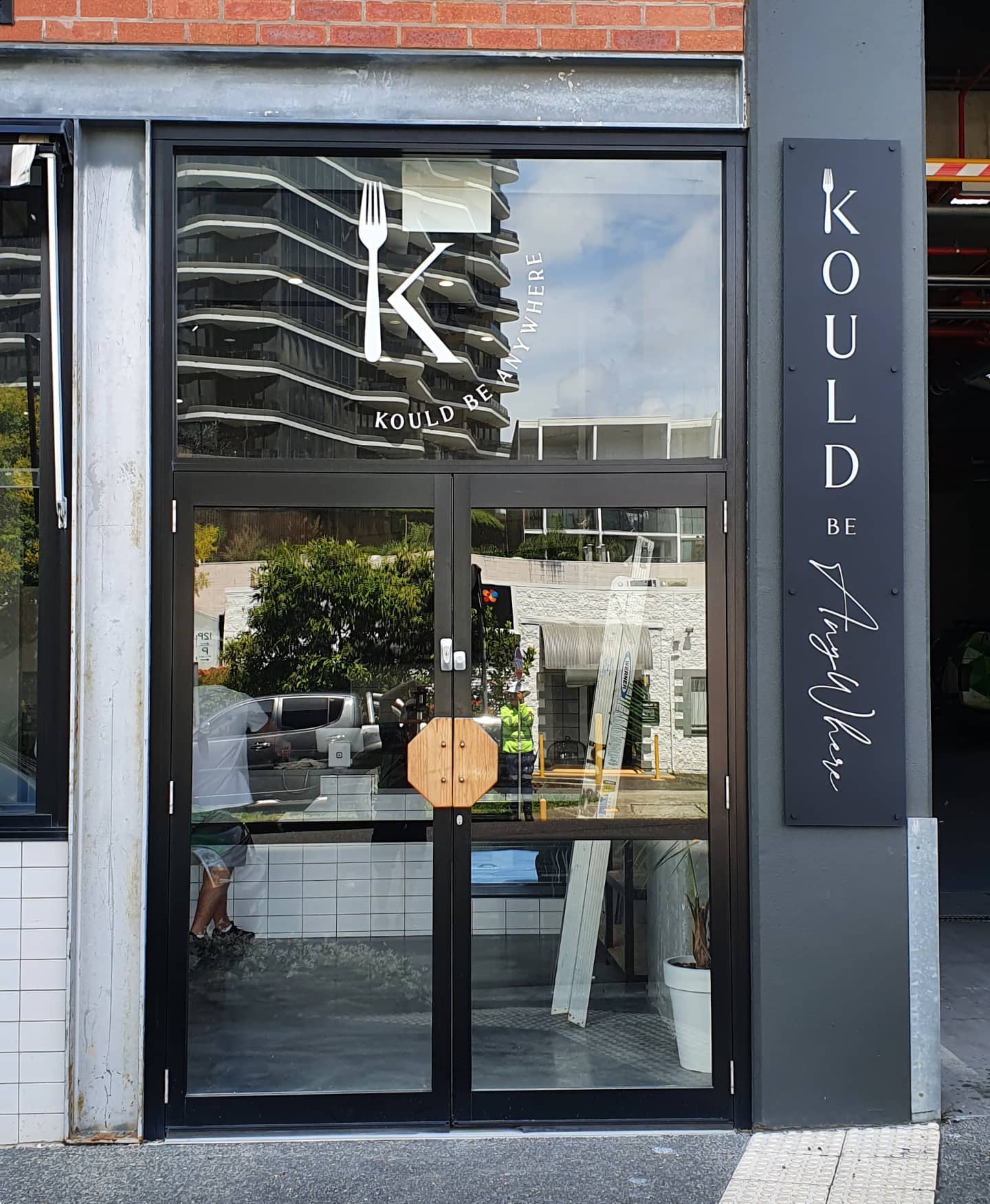 Vinyl cut graphics on top glass panel, matte acrylic sign, all graphics in reverse backed up with white, installed with matte black stand-offs on a concrete wall. #kouldbeanywhere #gabba #catering #woolloongabba #hcsigns #tradequalified #redlandcity #acrylicart