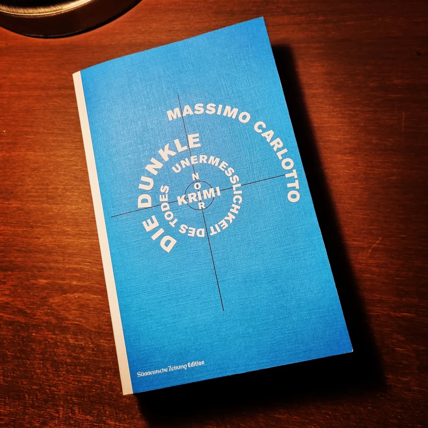 Mal wieder zur Literatur: Mit der Unterstützung von @horst.eckert.autor arbeite ich weiter fleißig an meinem Krimi-Projekt "Surf Noir" und das @literaturbuero.nrw und das @literaturhaus_bonn legen wie Vogelmütter ihre Flügel um mich. Ein schönes Gefühl der Geborgenheit.
Parallel lese ich mich lernbegierig durch die Krimiwelt. Dabei bin ich auf den Italiener Massimo Carlotto und seinen Roman "Die dunkle Unermesslichkeit des Todes"gestoßen (gibt's bei @tropenverlag und in einer #süddeutschezeitungedition "Noir Krimi" )
Wäre das hier nicht so ein seriöses Medium, ich würde sagen, diese Geschichte um Schuld und Sühne ist ein 150 Seiten Kopffick, so sage ich: welch intensives Leseerlebnis. Erinnert in seiner Dichte ein bisschen an "Postman always rings twice".
Der Plot: 15 Jahre nachdem zwei Gangster seine Frau und seinen kleinen Sohn ohne Grund erschossen haben, bietet sich dem gebrochenem Witwer die Gelegenheit, Rache zu nehmen. Und ich sage mal ohne groß zu spoilern, er macht von dieser Gelegenheit ausgiebig gebrauch.
Erzählt wird die Geschichte aus der Ich-Perspektive, der des Witwers und der des Gangsters, der geschossen hat. Die Perspektive brennt die Verzweiflung aller Beteiligten so richtig schön in den Kopf. Pro-Tipp: Das Buch nicht vor dem Einschlafen lesen, macht schlechte Träume. Ich hab's ausprobiert.
Das einzige, was ein bisschen nervt, ist die etwas bemühte Gangstersprache - vielleicht ein Übersetzungsproblem.
Memo an mich: Keine Modewörter wie "Kopffick" verwenden, die lassen ein Buch und einen Post schlecht altern.
Jetzt die große Mitmachfrage: Welche Krimis haben Euch zuletzt schlecht schlafen lassen?
#mentoring #autor #autorenleben #bookstagram #bookstagramgermany #bookstagramdeutschland #instabook #buch #lesen #krimi #buchempfehlung #krimiautor #bücherliebe @massimo_carlotto