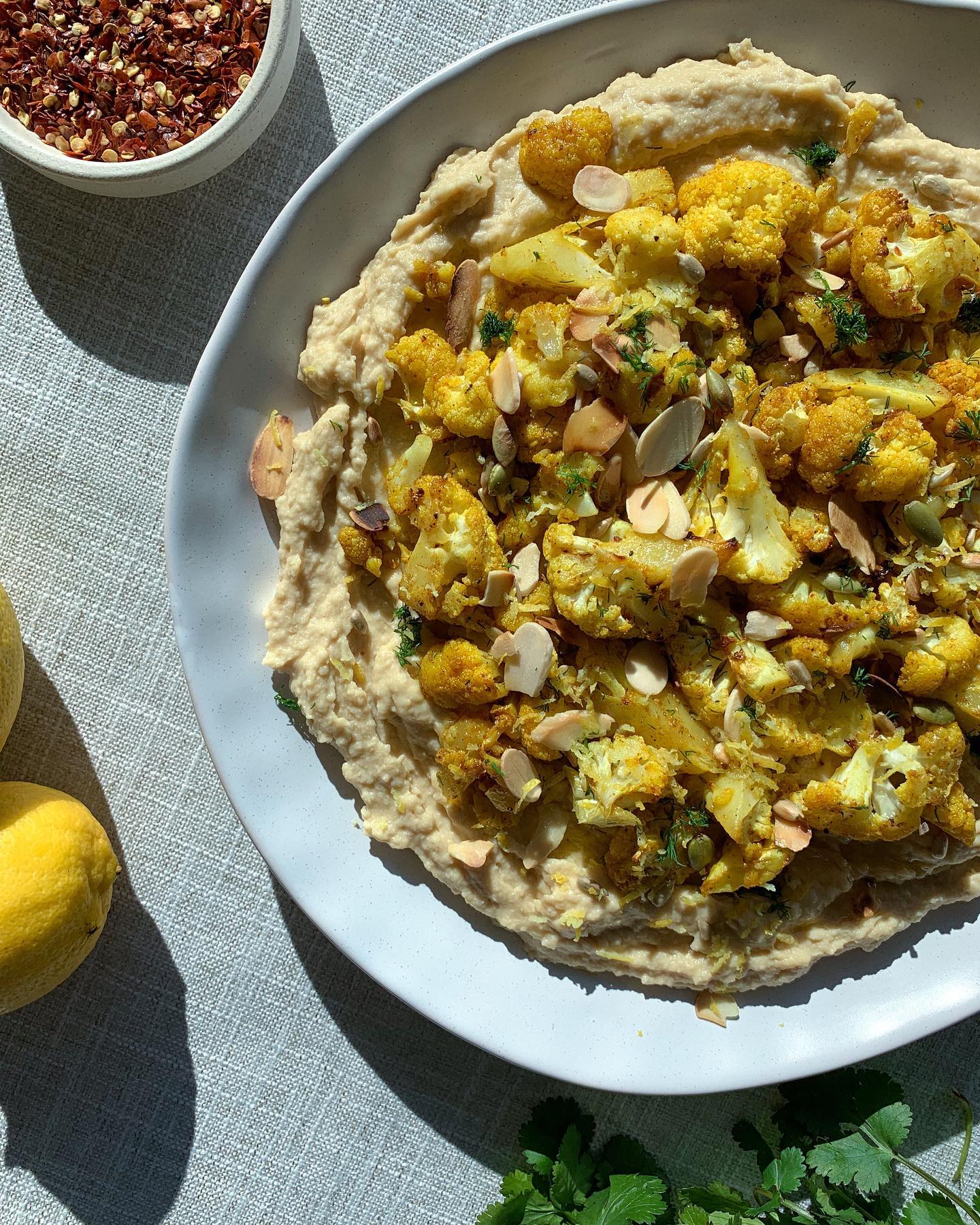 SPICED CAULIFLOWER LOADED HUMMUS
You’ll need:
1/2 head cauliflower
1/2 teaspoon turmeric
1/2 teaspoon garlic powder
1 teaspoon cumin
1 teaspoon chilli flakes
Zest of 1 lemon
Roasted nuts of choice (I used almonds)
Chopped fresh herbs
Olive oil
500g homemade hummus:
2 tins chickpeas
2 garlic cloves
1/2 cup tahini
1 tsp cumin
big glug of olive oil
juice of one lemon
s+p to taste
Method:
✼ Cut up your cauliflower and toss in all of your spices and olive oil. Roast for 25min.
✼ Blitz all your hummus ingredients in a food processor and spread out on a large plate.
✼ Top your hummus with the roasted cauliflower and finish with fresh herbs, lemon zest, roasted nuts and a good serving of extra virgin olive oil.
✼ Serve with crackers or crusty bread.
#hummus #easydip #easyrecipe #dinnerparty #spring #healthyfood #nutrition #loadedhummus #Tryfor5