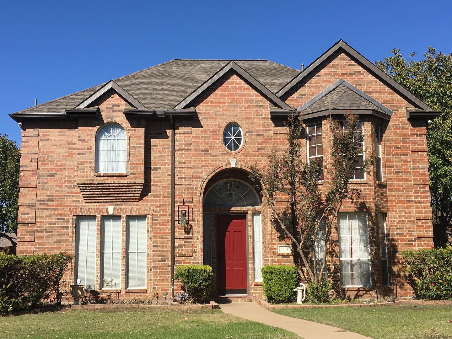 A couple of Plano re-roofs, steep and high. Dark Bronze gutters on the first. Both are Weathered Wood which looks great with any brick and paint color.