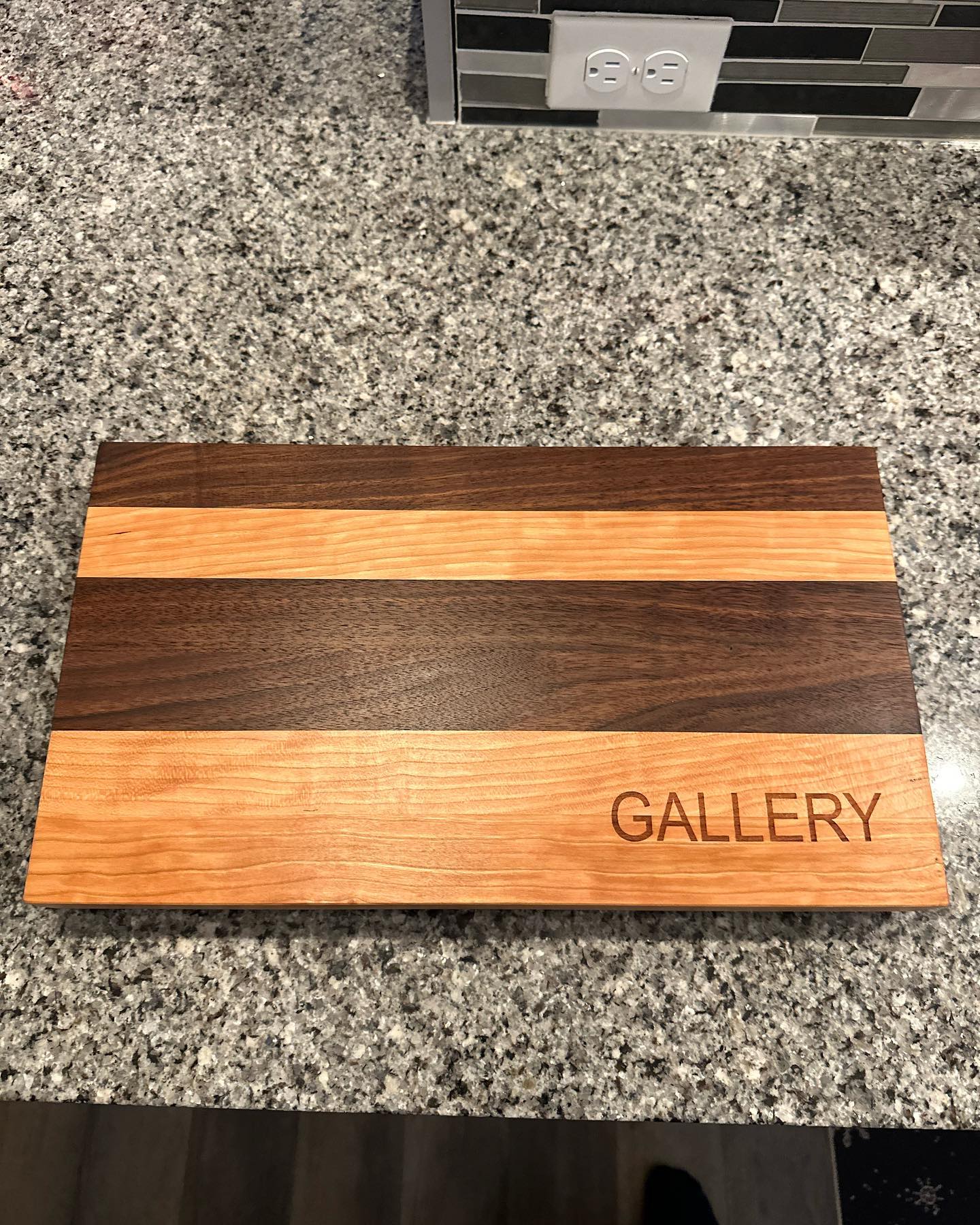 “Chocolate Covered Cherry” cutting board safe at its new home at the customers’ place. Looks great with their counter and back splash! Thanks for the purchase and the opportunity for us to create this beautiful board :) #woodworking #cuttingboard #laserengraving