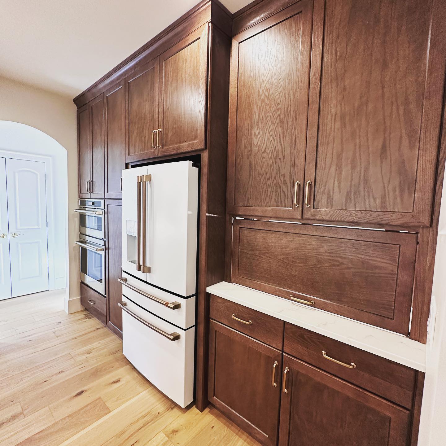 Just finished this beautiful and functional kitchen. The cabinet stain color is the perfect contrast to the beautiful hardwood floors. The tile hood makes the backsplash come together seamlessly. #customhome #customhebuilder #jontotherowconstruction #customkitchen #granitecountertops #coffeebar #cafeappliances #stainedcabinets #tileventhood #kitcheninspiration