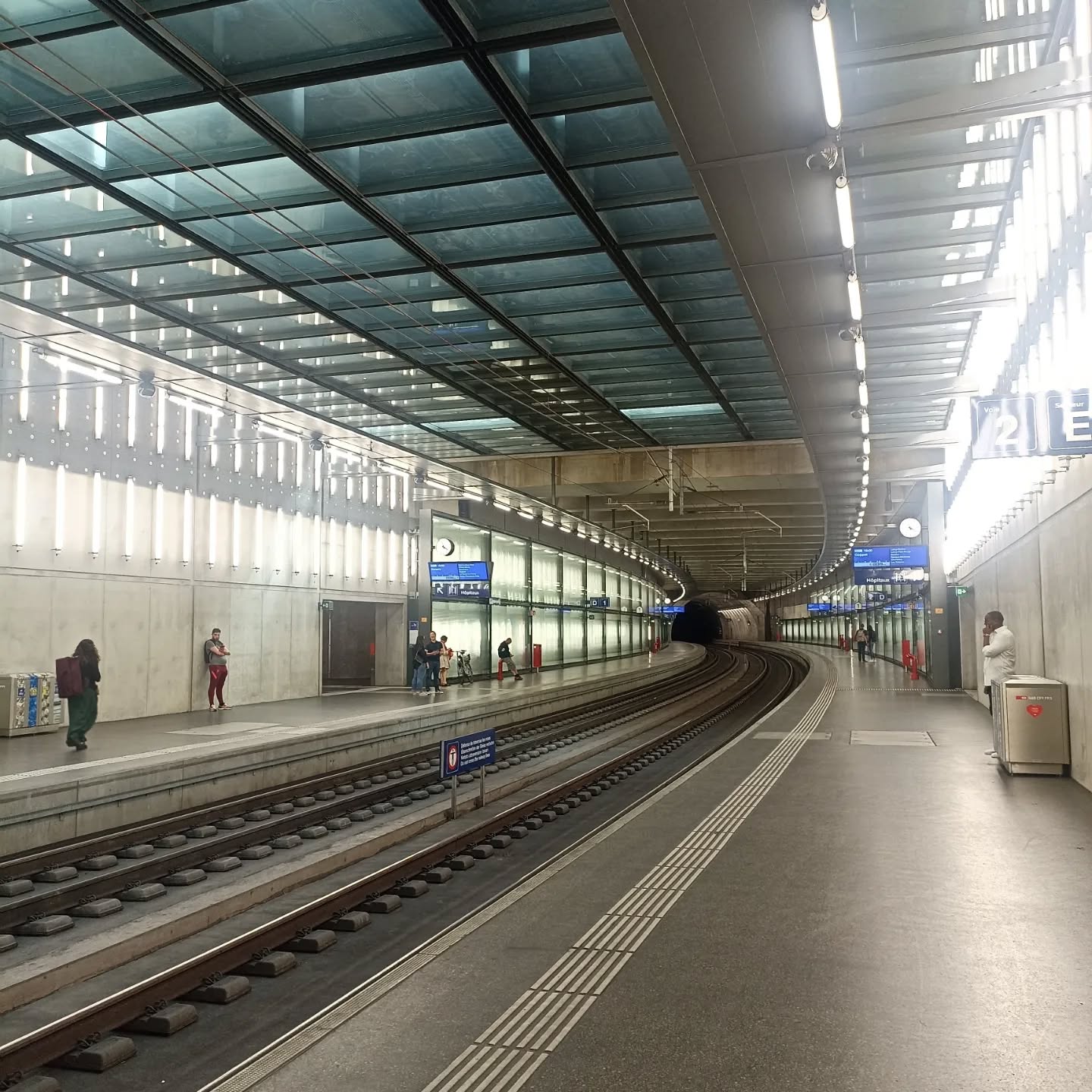 #gareceva #garecevachampel #garecevaeauxvives #garecevachenebourg #jeannouvelarchitect #architecturegeneva #architecturalguidedtours #architectureswitzerland #architecturalguidedtours #ingphi #jeannouvelarchitecte #atelierjeannouvel
The city of Geneva is home to five stations along the new CornavinâŻââŻEaux-VivesâŻââŻAnnemasse (CEVA) cross-border train line that connects Genevaâs Cornavin station in Switzerland to the Annemasse station in France.
The buildings of the five stations were built according to the same âglass brickâ architectural design aimed at bringing light all the way to the platform level. The glass brick is a glass facade element that measures 5.40âŻm (18âŻft.) x 2.70âŻm (9âŻft.) and was inspired by the glass paving stones used in 1930s architecture. They are used as roof, wall and floor elements.
Thus, the glass brick and their metal framework create a âCEVA identityâ in Geneva and link the Swiss and French rail networks to form the missing link of the LĂ©man Express that will connect the France-Vaud-Geneva megalopolis.
Source: ingphi.ch