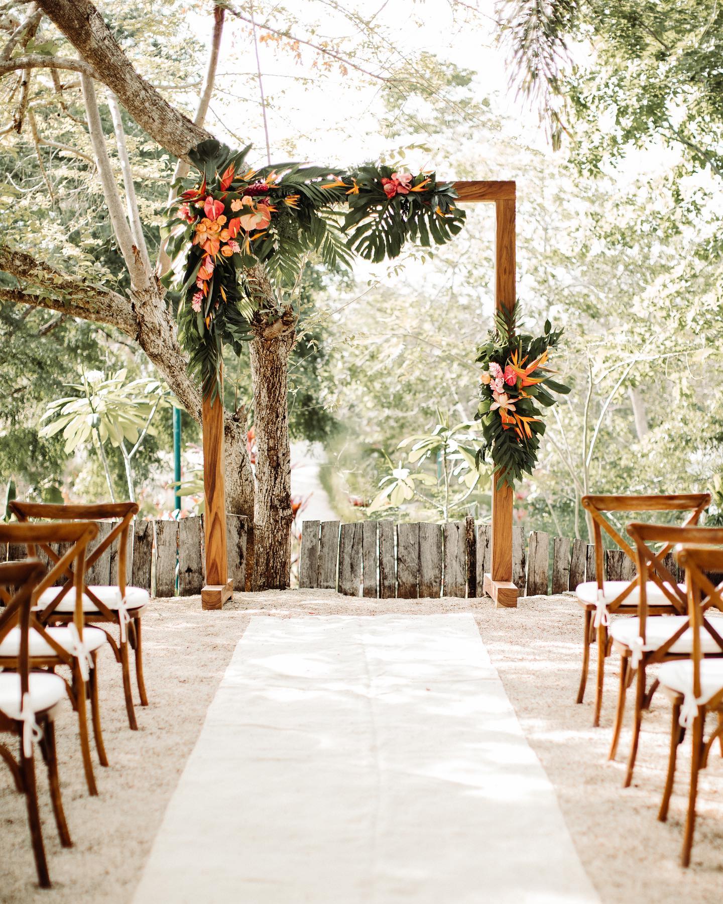 A popular arch design that never goes out of style: tropical leaves with a pop of color. 🌿🌺