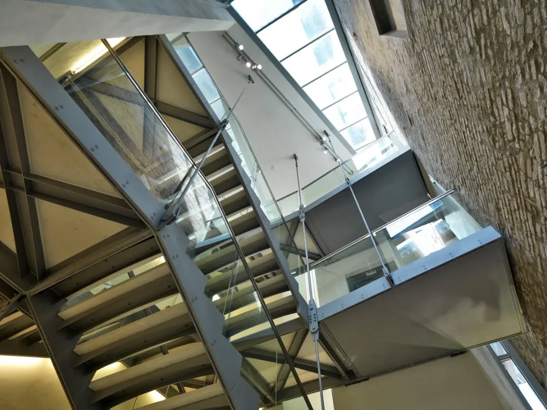 Nuovo corpo scale e ascensore - Biblioteca Classense, Ravenna.
Realizzato tra il 2006 e il 2008, durante uno degli stralci riguardanti il restauro dell'intero complesso della Biblioteca, il nuovo corpo scale-ascensore collega piano terra, ammezzato e primo, rendendoli accessibili a tutti. La nuova aggiunta si distingue dell'esistente mediante i volumi puri dell'esterno e il linguaggio contemporaneo dell'interno, e anche grazie alla presenza di un taglio vetrato in corrispondenza del muro storico, che dalla copertura discende fino a terra lungo i fronti laterali. Tuttavia il volume non prevarica sull'esistente, e dall'esterno trova un dialogo con la storicità mediante una riproposizione moderna della parete in muratura listata.
All'interno la scala in acciaio è appesa alla copertura, galleggia nello spazio, è una struttura in acciaio ma leggera. L'intera scala è rifinita con materiali ricercati, che conferiscono la necessaria dignità per un elemento inserito in un luogo ricco di storia e cultura.
Il contemporaneo si confronta con l'antico.
#architects #engineers #designers #architecture #restoration #design #community #building #adeptarchitects #drawing #construction #underconstruction #historical #building #heritage #moderndesign #architecturephotography #classense #bibliotecaclassense #biblioteca #myravenna #ravenna #library