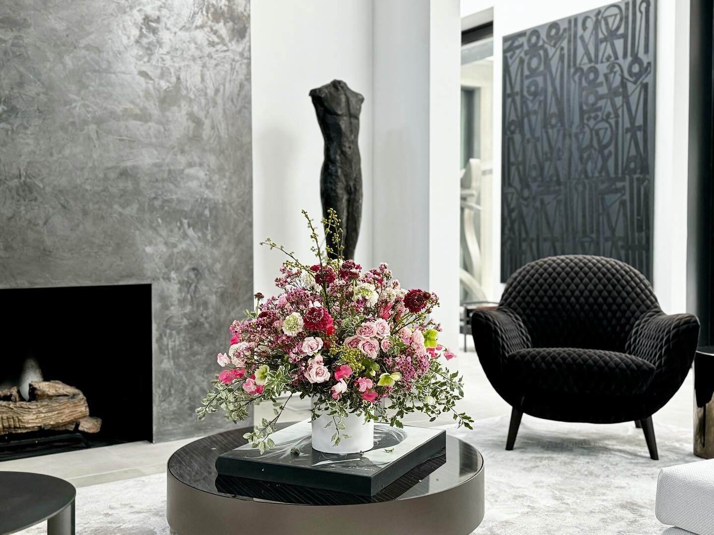 A pop of color amidst the monochrome! Art and nature harmonize in this stylish home. #art #interiordesign #flowers