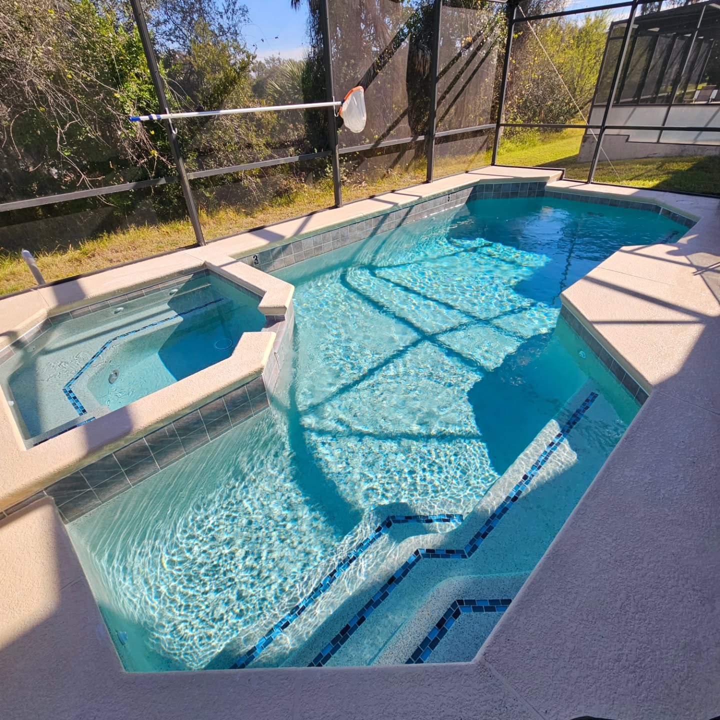 Freestone Pebble with Blue Mix Glass for this pool/spa. Mosaic tile bands added to stairs and benches for extra pop.