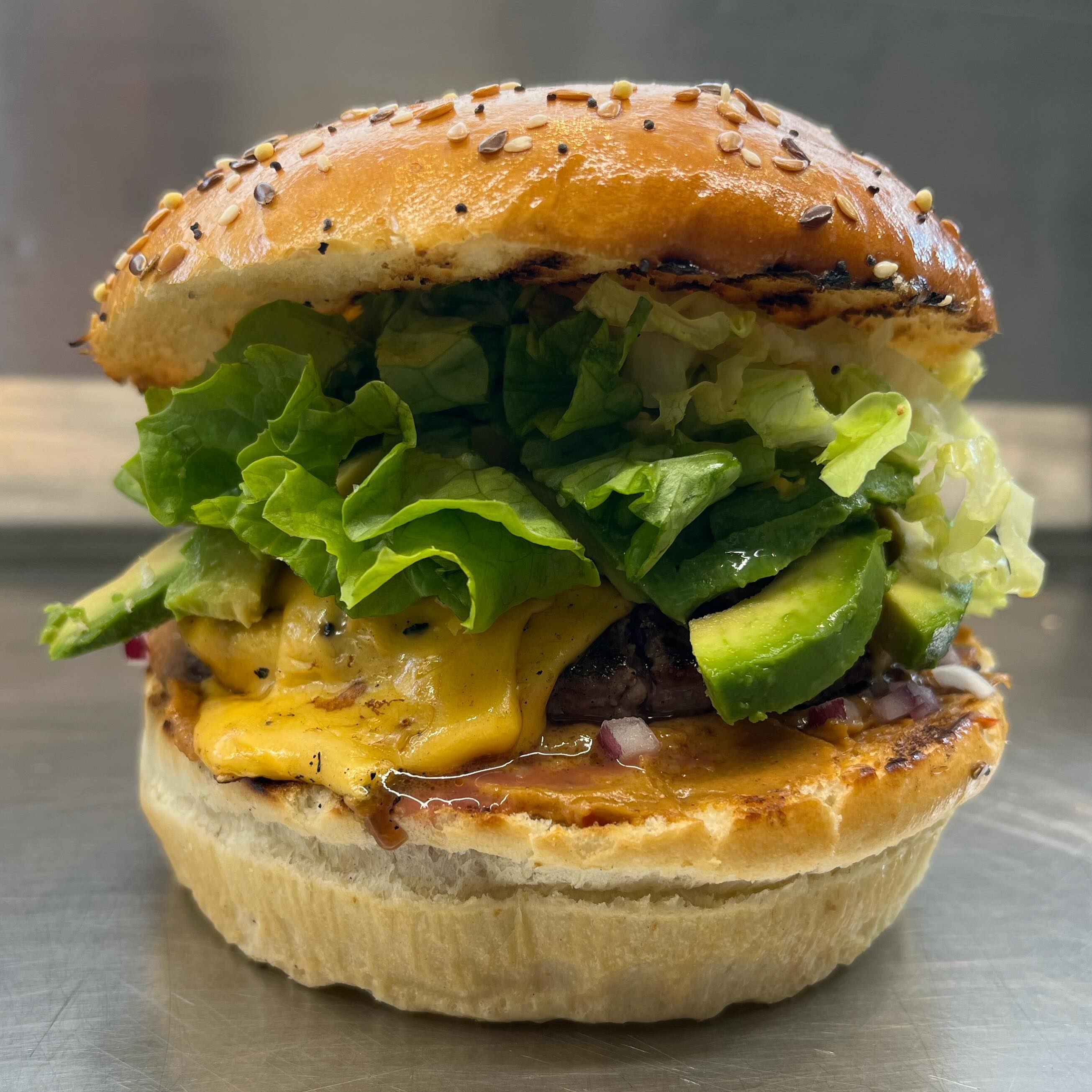 Burger du mois: sauce satay, oignons rouges, steak haché double cheddar et lamelles d’avocats