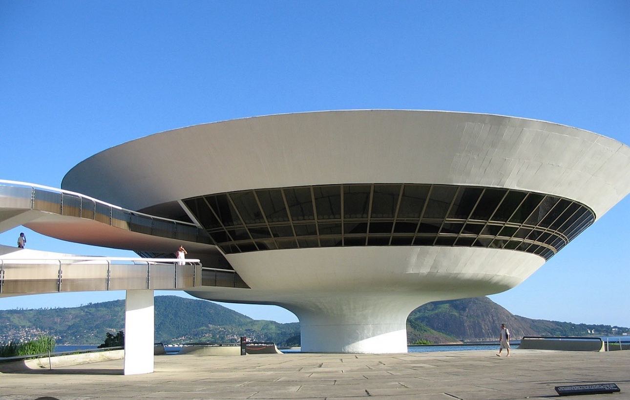 Le Musée d’art moderne a été dessiné par Oscar Niemeyer assisté de l'ingénieur Bruno Conrini qui avait déjà travaillé avec lui lors de projets précédents. La construction du musée dura cinq ans, pour ouvrir en 1996. Le bâtiment fait 16 mètres de hauteur, sa coupole comporte trois niveaux ayant un diamètre allant de 18 à 20 mètres. L'ensemble est en béton brut peint en blanc pur. Le musée se reflète dans de Boa Viagem (Bon Voyage), la piscine-miroir de 817 m2 qu'il domine grâce à sa base cylindrique de 9 mètres de diamètre à partir de laquelle le bâtiment se développe « comme une fleur », selon les propres mots de Niemeyer. Autour du musée, une place de 2 500 m2 est aménagée pour permettre de bien dégager la silhouette de l'édifice.
On peut contempler la baie de Guanabara et le mont du Pain de Sucre au loin. La structure résolument futuriste en soucoupe volante, semblable à un ovni, est posée sur une falaise qui se termine par une plage. Dans le film Oscar Niemeyer, un architecte engagé dans le siècle Niemeyer est montré en train de voler dans un ovni au-dessus de Rio de Janeiro puis atterrit à l'endroit du site, suggérant que ceci est la véritable origine du musée. www.lhommederio.fr #riodejaneiro #joiedevivre #amitié #favela #elenao
#lyon #progres #beauté #population #christ #redemption #jeanpaulbelmondo
#beaute #samba #carioca #beaute #carnaval #christ #redemption #corcovado
#enfant #favelas #elephant🐘 #dieux #deus #amour #love #belmondo
#gang @faveladopaulinho #livre #enfance #belmondo #lhommederio.fr