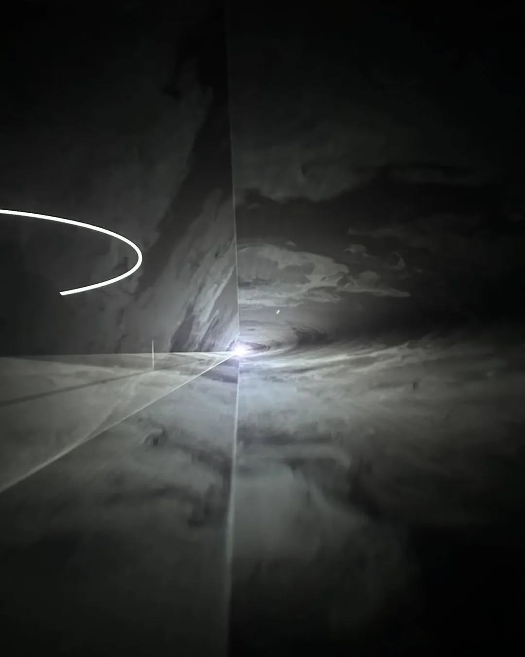 After presenting Anthony McCall at DAS 2023, we are happy to share images of Tate Modern’s beautiful exhibition 'Solid Light' - featuring immersive light installations by McCall - who is one of our favorite artists.
During the DAS 2023, we presented Anthony McCall's "Line Describing a Cone 2.0, 1973/2010" from the Samdani Art Foundation Collection. Like watching the sunset, experiencing "Line Describing a Cone" requires a duration of 30 minutes to watch a white curve appear and transform in space. Here, a thin mist flows into the room, allowing the viewer to progressively see a large cone of light which simultaneously becomes a light sculpture that the audience can walk into, almost like a portal into another universe. This work is not just something to watch; it is a universe to be absorbed in and to participate in.
The next theme of our 7th edition of DAS is TONDRA. The meaning of the word TONDRA in Bangla can be described as a state of existence where reality and dreams collide; a lucid dream that captivates the soul. Our story of TONDRA emerged from heartbreak expressed by a young visitor at DAS 2023, who wrote messages for a woman named TONDRA on the walls of our exhibition. One of the first writings we found was at Anthony McCall's space. TONDRA is a journey through the landscapes of emotions, where the line between what we feel, what we see, and what we imagine becomes blurry.
Anthony McCall's "Line Describing a Cone" and TONDRA both create immersive, transformative experiences. McCall's light sculpture forms an almost otherworldly space, inviting viewers to enter a new universe by facing the projector and making space and light tangible. Similarly, TONDRA draws people into a dreamlike state where reality and dreams collide, engaging them deeply in an emotional and introspective journey.
Photograph 1,2, 3 - Installation view of 'Solid Light' at Tate Modern
Photogrpah 4&5 - Messages left behind for a girl named Tondra by a young visitor during the 2023 Dhaka Art Summit at Anthony McCall's space.
Photograph 6,7&8 - Installation view Anthony McCall's "Line Describing a Cone 2.0, 1973/2010 from DAS 2023.