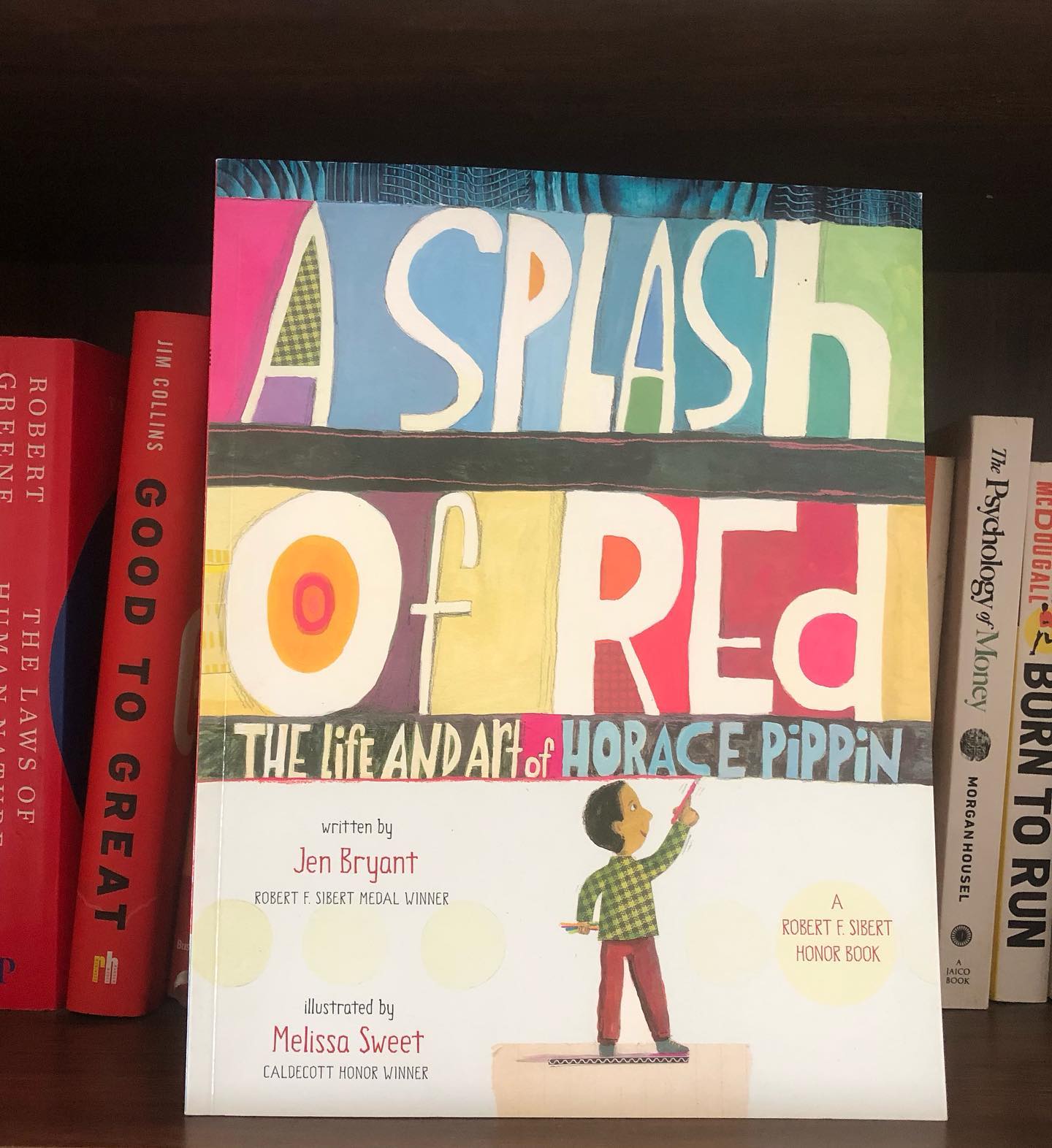 A Splash of Red: The Life and Art of Horace Pippin
By Jen Bryant
Illustrated by Melissa Sweet
This wonderful book tells the inspiring story of Horace Pippin, a boy who pursued his passion for art despite incredible hardships. It is a testament to his resilience and determination, illustrating how one man’s unyielding spirit triumphed over adversity.
Pippin’s childhood was marked by struggle. From an early age, he had to work to support his family, but it was also during this time that he discovered his love for art. After winning a childhood art competition, he received his first set of paints—marking the beginning of a lifelong artistic journey.
However, Pippin’s path was not easy. His service in World War I left him with a severe injury to his right arm, a blow that could have ended his artistic career. Yet, Pippin’s tenacity shone through. Despite his injury, he spent years teaching himself to paint again, using his left hand to guide his right.
This biography charts Pippin’s extraordinary life, from being a poor school dropout without access to art supplies to becoming a celebrated artist whose work is displayed in renowned galleries. It’s a moving story of perseverance, passion, and hard work.
The mixed media illustrations, enriched with Pippin’s own quotes, beautifully complement the narrative, adding depth to both the artwork and the story. The book also includes extensive back matter, providing a wealth of resources for further exploration and research. For those who love delving into the lives of artists, this book offers a true source of inspiration.
Recommended for children aged 5 and up. #kidsbookstagram #kidsbookreviews