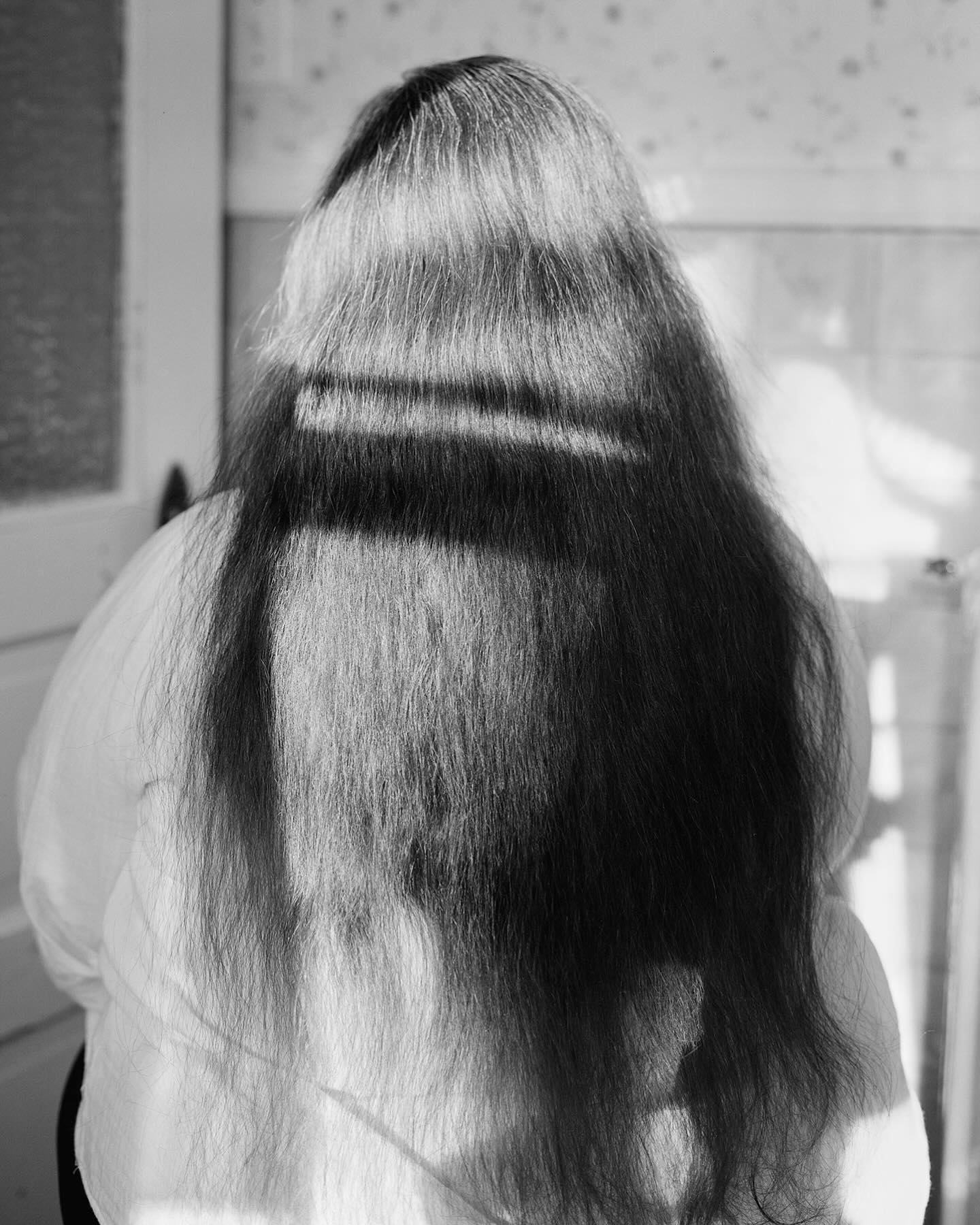 Cassie Jain (@cassie.jain) is a photographer, art historian, and educator. She recently completed her MFA in Photography & Related Media at SUNY New Paltz, and holds a BA in Art History from Vassar College. Her practice is rooted in analogue photography and in the tactile and ritualistic possibilities of image-making. Most recently, her research celebrates ephemeral party spaces, particularly those rooted in queer aesthetics and theory, and friendship as sites of self-expression and tenderness.
The title of this image is ‘Mommy Hasn’t Cut Her Hair Since the Pandemic.’ “The world is difficult and tiring and yet something pushes us to stay. We embellish and adorn ourselves, and create something out of nothing, no matter how ephemeral or futile. We love and lose and recreate these spaces with those we trust and those who understand the need for them to exist. I make pictures because I don’t know how not to. Derek cracks a whip to celebrate the dead. Gokul dances capoeira on the Rail Trail, and teaches class in an empty gymnasium. Maggie dances in the woods when she’s angry and upset. Eilif and I paint our nails on the edge of their bed. Max and I throw ‘darkroom parties’ when we develop a roll of film.
This is what it looks like to be tender — vulnerable to the good within the darkness.”
Check out Cassie’s work and others in the Golden Hour issue of Pearl Press at pearl-press.com/goldenhour
-
#pearlpress