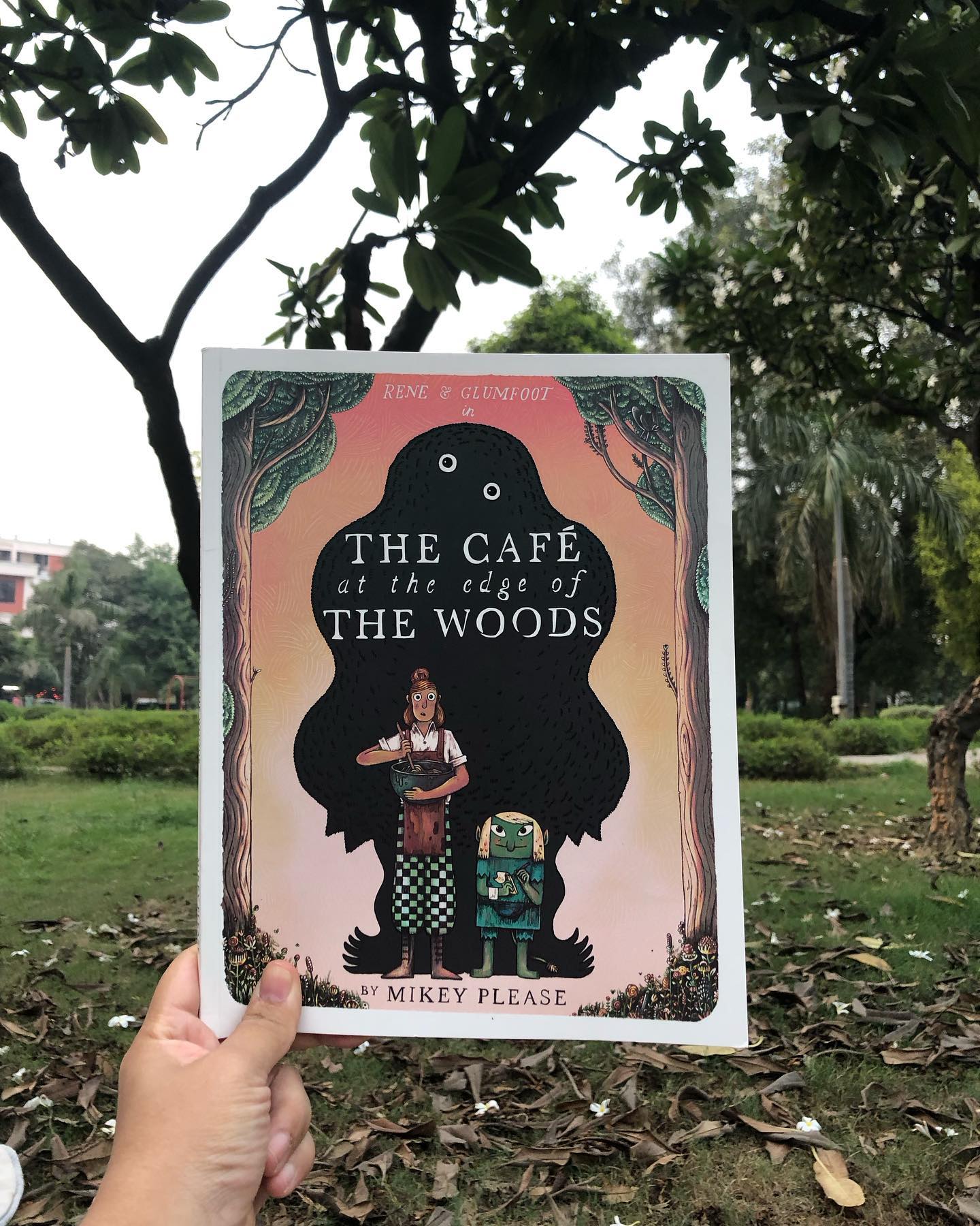 Cafe at the Edge of the Woods
By Michael Please
Rene, an ambitious young chef with a talent for creating exquisite dishes, finally realizes her dream of opening her own cafe. However, when she advertises for staff, only one applicant shows up—a small green creature named Glumfoot.
Despite this unusual partnership, the cafe opens each day to empty tables, leaving Rene disappointed and discouraged by the lack of customers.
In an attempt to boost their clientele, Glumfoot brings an unexpected guest: an ogre with a peculiar palate, craving only the most revolting concoctions. Though Rene prides herself on quality cuisine and refuses to compromise, Glumfoot ingeniously redecorates the food to suit the ogre’s unusual tastes—something every parent can relate to when serving a picky toddler. The ogre leaves delighted, proving that, sometimes, a little creativity can make all the difference.
Set against a charming retro backdrop, Cafe at the Edge of the Woods enchants readers with its detailed illustrations, quirky characters, and a delightful array of folklore figures. This whimsical tale is a joy for readers of all ages.