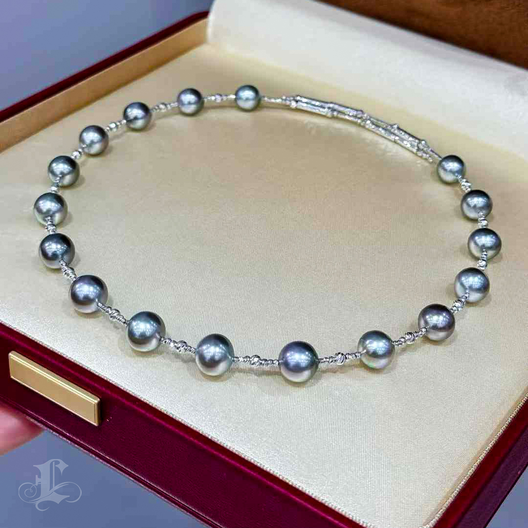 This luxurious necklace features platinum-gray Tahitian pearls with a stunning aurora-like luster. Each pearl is carefully strung on a shimmering 18K white gold elastic chain, offering elegance and flexibility. The unique magnetic clasp allows for easy adjustment, letting you customize the length to complement any outfit or occasion. A dazzling combination of timeless pearls and modern design, this necklace is a perfect statement of sophistication and versatility.
#tahitianpearljewelry
#tahitianpearlnecklace