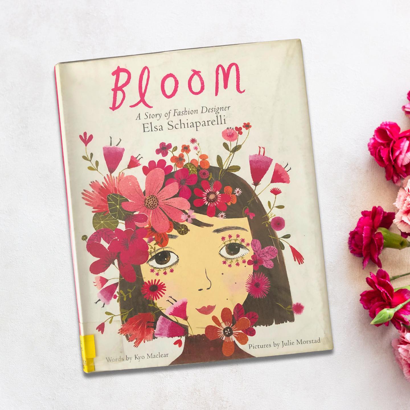 Bloom: A Story of Fashion Designer Elsa Schiaparelli
By Kyo Maclear
Illustrated by Julie Morstad
This beautifully crafted book is a fictionalized biography of Elsa Schiaparelli, the iconic designer whose bold and surrealist-inspired creations revolutionized the fashion world in the late 1920s. Today, her haute couture brand remains celebrated and relevant globally.
The story introduces Elsa as a child grappling with self-image issues, often overshadowed by her more “appealing” sibling. In a poignant moment, young Elsa tries to transform herself by planting flower seeds in her eyes, ears, and mouth—an act of desperation that leads to a medical intervention. While this plan was a failure, it marked the beginning of her transformation in how she viewed herself and the world around her.
Elsa’s journey was far from easy. It was filled with struggles, setbacks, and moments of self-doubt. However, her immense talent and unrelenting determination eventually propelled her into the spotlight. With her signature eccentricity, bold imagination, and the creation of her iconic “shocking pink” designs, she became one of the most influential figures in the history of fashion.
This book is a truly inspirational read, highlighting the courage and resilience of a woman who defied expectations to leave an indelible mark on her industry. The stunning illustrations by Julie Morstad are a standout feature, with their minimalist elegance and a carefully chosen shocking pink palette that beautifully complements Elsa’s story.
Perfect for children aged 6 and above.