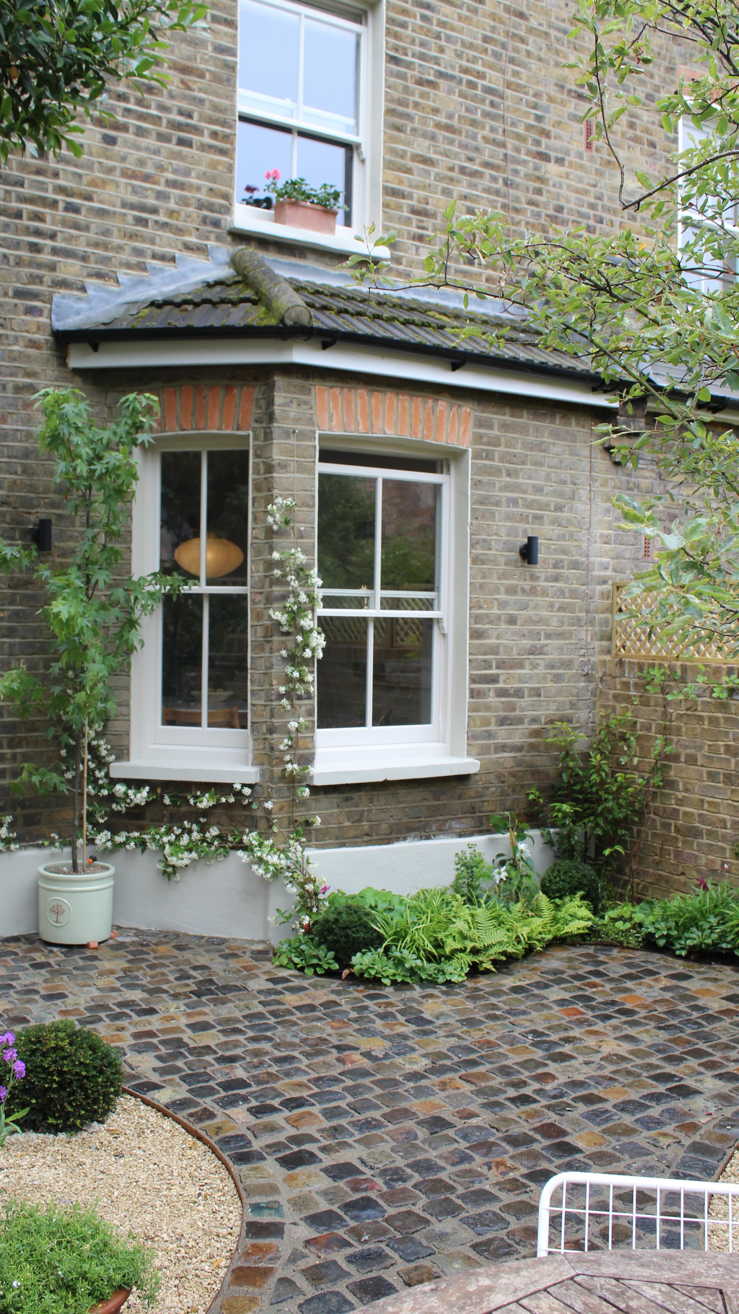 Charming cobbled garden in East London that was completed last week.
We used some mixed reclaimed granite Stone Setts for the main pathway paired that with Cotswold Pebbles.
Loads of textured evergreen planting as well as some colourful perennials and annuals to bring a pop of colour.
The entire boundary wall has been built from scratch and we went for a traditional London stock to tie in with the exterior of the house.
In time all the vertical spaces will be covered in greenery once they establish. 💚