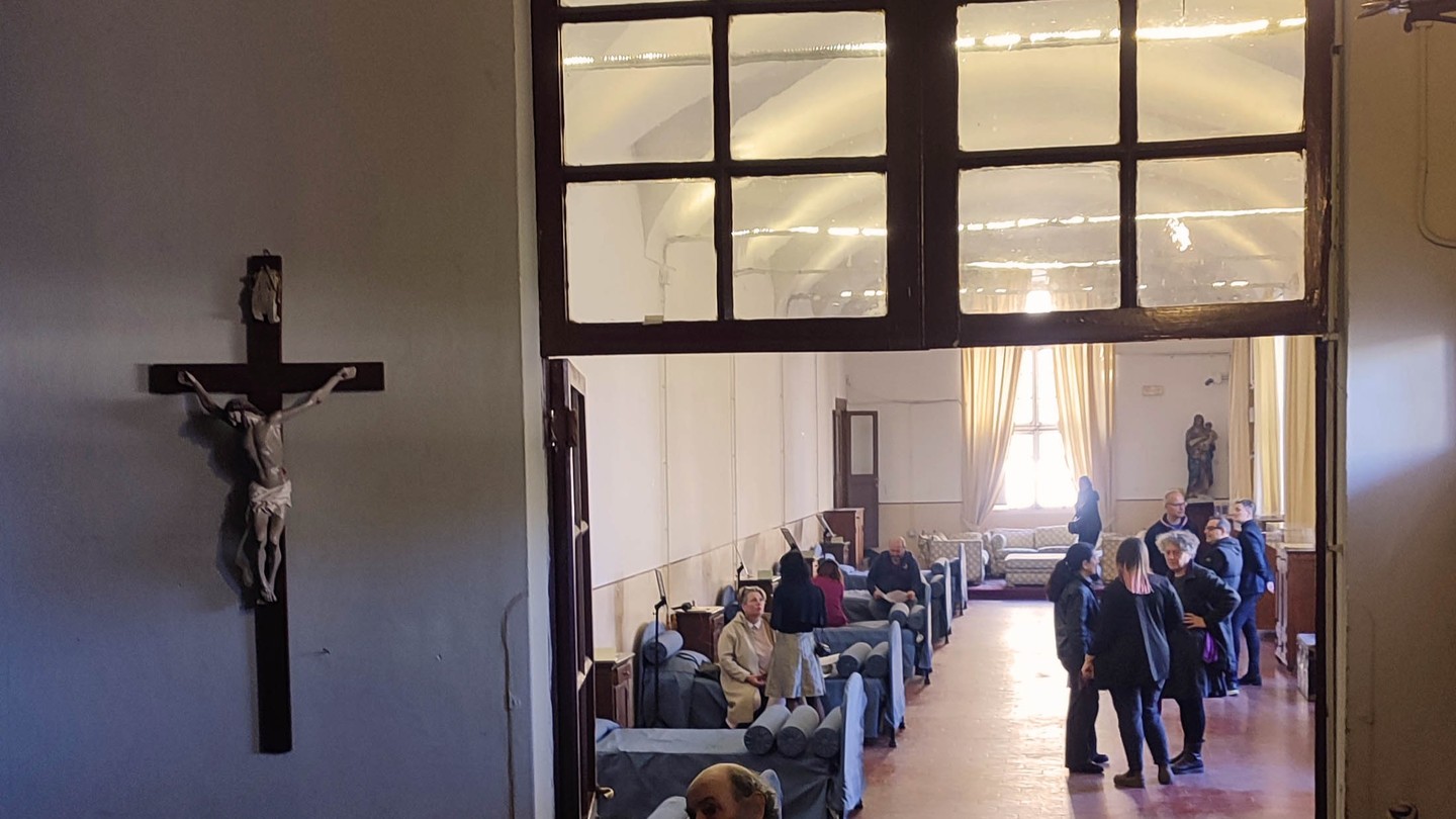 Il cuore è la sede delle nostre emozioni, pulsioni, aspirazioni, come Anahi Mariotti mostra in questa originale installazione artistica.
Inaugurazione e presentazione al pubblico dell'installazione "Quando viene la sera", frutto della performance dell'artista Anahi Mariotti, realizzata interagendo con gli anziani e i volontari che se ne prendono cura, spaziando nell'ambiente circostante, il rione di Trastevere, il fiume.
Una creazione singolare e coinvolgente, presentata al pubblico dall'artista in questo evento che porta a compimento il percorso iniziato con l'evento "Come un fiume d'acque celesti" e la mostra fotografica "Gli ospiti", e si concentra sul cuore, sede dei sentimenti, degli affetti, delle pulsioni.
Dell'esperienza, vissuta in chiave emozionale e performativa, l'artista lascia una traccia tangibile e irripetibile, rielaborando tracciati cardiaci, disegni, appunti, frammenti audio, dando vita all'installazione che porta l'osservatore a entrare in empatia con un mondo di stimoli sensoriali e affettivi.
Curato da Roberta Melasecca, il progetto dell'artista Anahi Mariotti si struttura in due fasi: un primo momento performativo e un secondo installativo-espositivo.
Nel corso di un tempo di 24 ore l’artista registra tramite un Holter cardiaco le prestazioni del suo cuore: a sovrapporsi al ritmo del tempo c’è sempre il ritmo del nostro cuore, il ritmo del pulsare delle vene, della respirazione. Il tempo, le ore che passano, 24h.
Il cuore, il battito cardiaco, le pulsazioni. Quanto incide ciò che accade fuori da noi sul nostro corpo? Può una conversazione, una situazione, un pensiero, variare il nostro ritmo interiore? Può un elettrocardiogramma essere letto come uno spartito? Cosa l’artista ha fatto, cosa ha visto nella performance verrà poi svelato durante il momento espositivo: foto, disegni, oggetti, nonché il grafico dell’elettrocardiogramma permetteranno al pubblico di entrare in contatto con una parte intima del corpo dell’artista.
Tutti gli elementi realizzati sono esposti sui comodini del museo-ex dormitorio dell’Ospitale della Fondazione Francesca Romana, come fossero momenti di una giornata ricordati prima di andare a dormire.