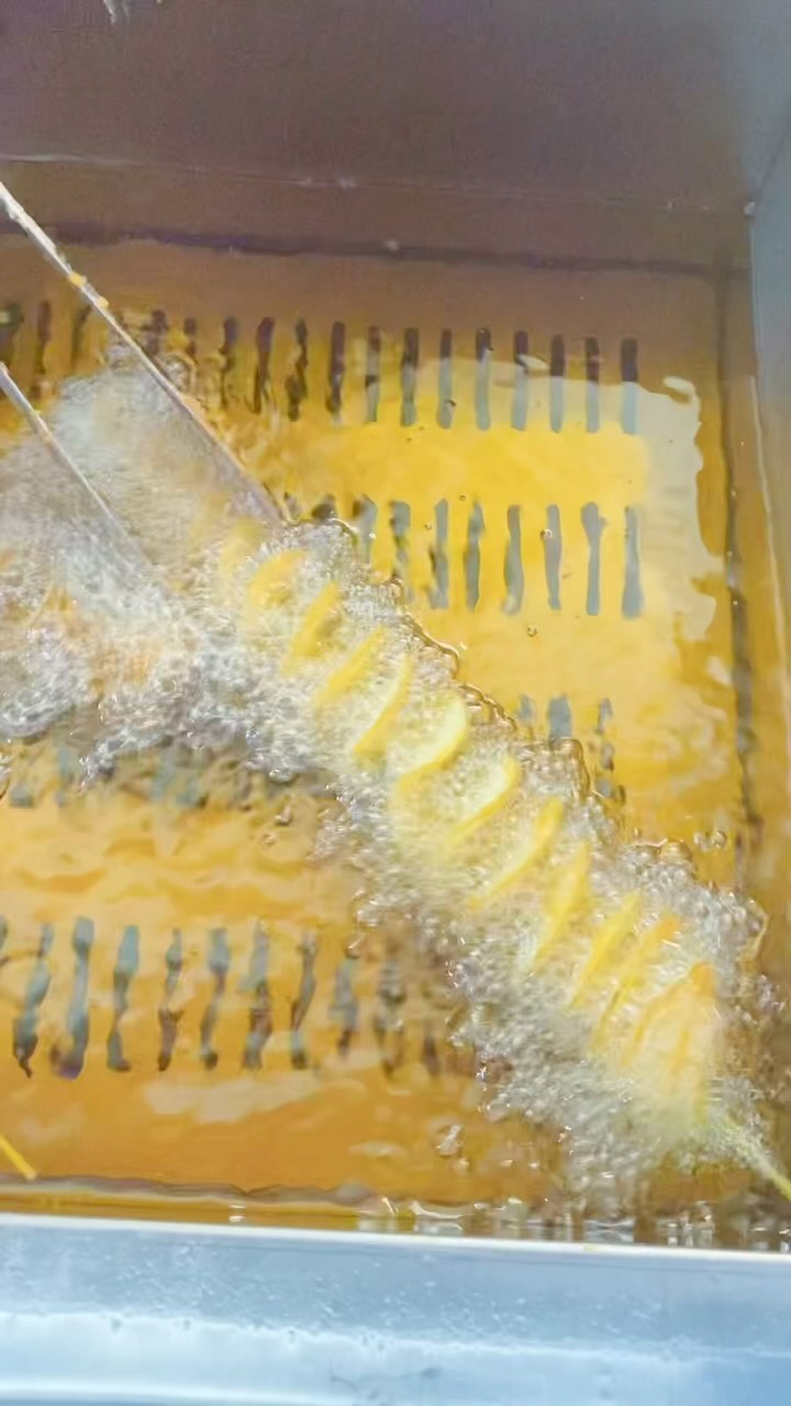Is it Real? Takonut invest a good quality fryer just to fry tornado potato? Yes, it is ! Using an oil-water separation commercial fryer offers several benefits, particularly in the food industry, where quality and safety are paramount:
1. **Extended Oil Life**: The separation of oil and water helps to prolong the life of the frying oil. Water and food particles settle in a separate layer, reducing the amount of oil absorbed and minimizing the degradation of the oil.
2. **Improved Food Quality**: By keeping the oil cleaner for longer, the taste and quality of the fried food are enhanced. It prevents the food from absorbing unwanted flavors or becoming greasy.
3. **Cost Efficiency**: Since the oil lasts longer, the frequency of oil changes is reduced, leading to cost savings over time. Additionally, less oil absorption means lower oil consumption.
4. **Safety**: The separation process helps prevent dangerous splattering or boiling over, as water and oil are kept separate. This reduces the risk of accidents in the kitchen.
5. **Ease of Maintenance**: The design often includes features that make cleaning and maintaining the fryer easier, such as easy access to the water and oil separation areas.
6. **Healthier Cooking**: Reducing the degradation of oil means fewer harmful compounds are produced during frying, making the cooking process healthier for consumers. #GoodFryer #HappyStaff #FasterProduction #GdFoodQuality