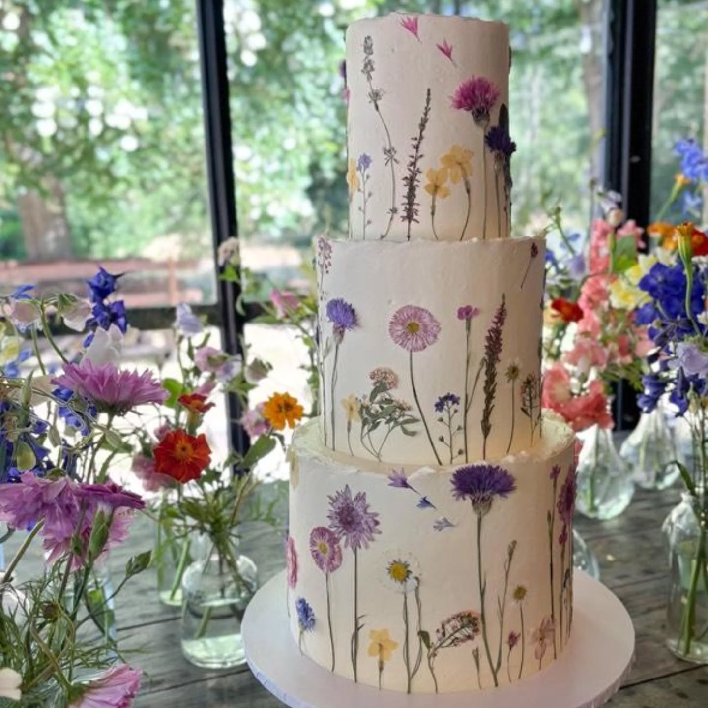 🪻Delicate charm meets wild beauty🪻
This gorgeous cake by @carascreativecakes is dressed with a selection of our pressed flowers including Cornflowers, Daisies and Heather - each bloom carefully preserved to capture its wild magic.
Framed with the most beautiful fresh and vibrant flowers, it's a celebration of nature's elegance.
#summerwedding
#cakeflowers
#edibleflowercake
#pressededibleflowers
#britishgrownflowers
#summervibes
#flowersforcakes