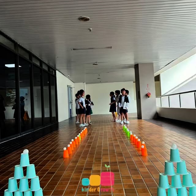 💪🏼🧠 Ball Toss Meets Brain Boost 🎯
Where playtime is purposeful and every flip counts.
This week, our Primary 1 and 2 Kinderians took their learning outside the classroom and into motion—with a simple set of cups and ping pong balls, we created a dynamic lesson in gross motor development.
At first glance, it may look like just fun and games. But every toss, every catch, every stacked cup was a quiet training ground for their young bodies and minds.
Through this Ball Flip and Cup Stacking activity, the children practiced vital skills we often overlook—balance, coordination, and focus. They bent low to balance a ball, reached high to complete a stack, and learned to time their tosses with patience and control.
In moments of success, we saw confidence bloom. In moments of toppled towers or missed catches, we saw perseverance. And in between, we witnessed collaboration: peers cheering each other on, encouraging retries, and celebrating every ‘almost-there’.
What may seem like a simple physical challenge was in fact a layered experience:
✔️ Body awareness in motion
✔️ Focused attention under pressure
✔️ Learning from mistakes in real-time
✔️ Joy in movement
At Kinder Growth, we believe these are the moments that shape more than just motor skills—they build resilience, agency, and a love for learning through action.
Because here, every move matters.
And every child deserves a space where growth feels like play.
🎯✨ #KinderGrowth #GrossMotorSkills #LearningThroughPlay #KinderiansInAction #BallFlipChallenge #CupStackingChallenge #MotorSkillsMatters #WholeChildDevelopment #WhereConfidenceTakesRoot #StudentCareSingapore #P1P2LearningFun #AfterSchoolWithPurpose