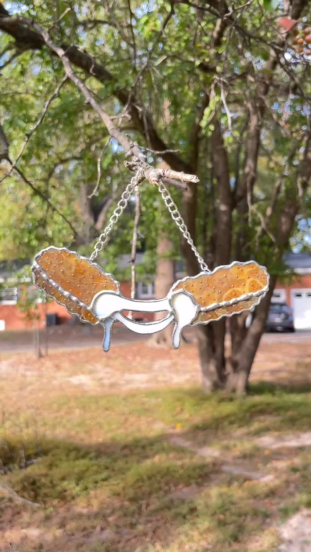 Sorry, I can’t hang out, I’m too busy working on our business… aka finding trees to hang this mozzarella stick from and photographing it like the paparazzi. Was just thinking it’s been too long since a good shot of this design graced our feed! 🥰 #stainedglassartist #stainedglassart #paigeboy #stainedglass #mozzerella #mozzarellasticks