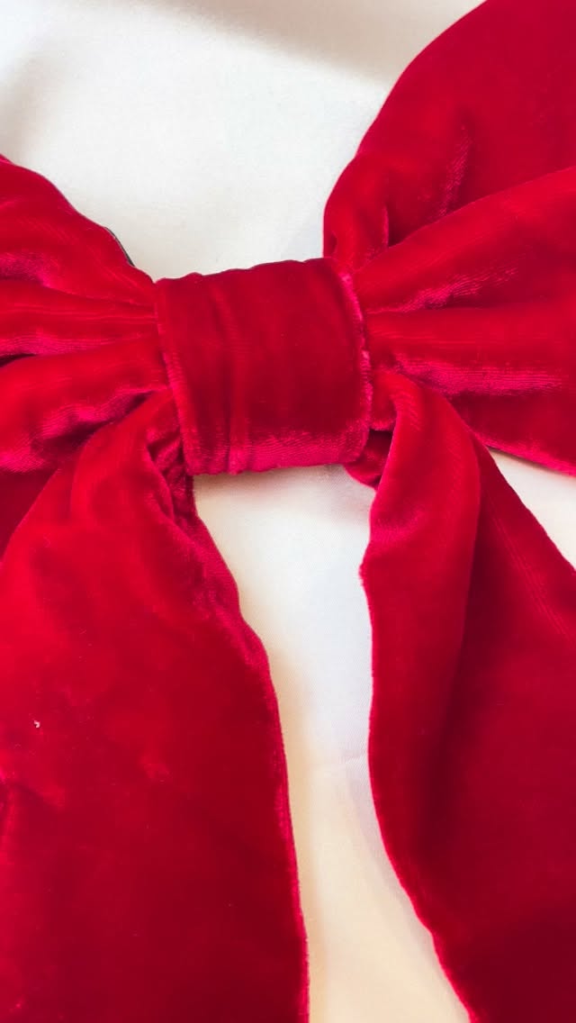 I needed to make a video of this silk velvet tree bow to show of the beautiful depth of colour you get with the velvet pile. These come with an adjustable elastic for positioning on the top of your tree and are a beautiful heirloom piece with a hand stitched finish, designed to adorn your tree for years to come.
These don’t just need to be limited to trees; bannisters, door handles and wreaths are all worthy contenders for bow decoration!
Video description – A large deep red velvet bow designed to be used for decor is turned around to show the elastic loop for attaching the bow while festive music plays