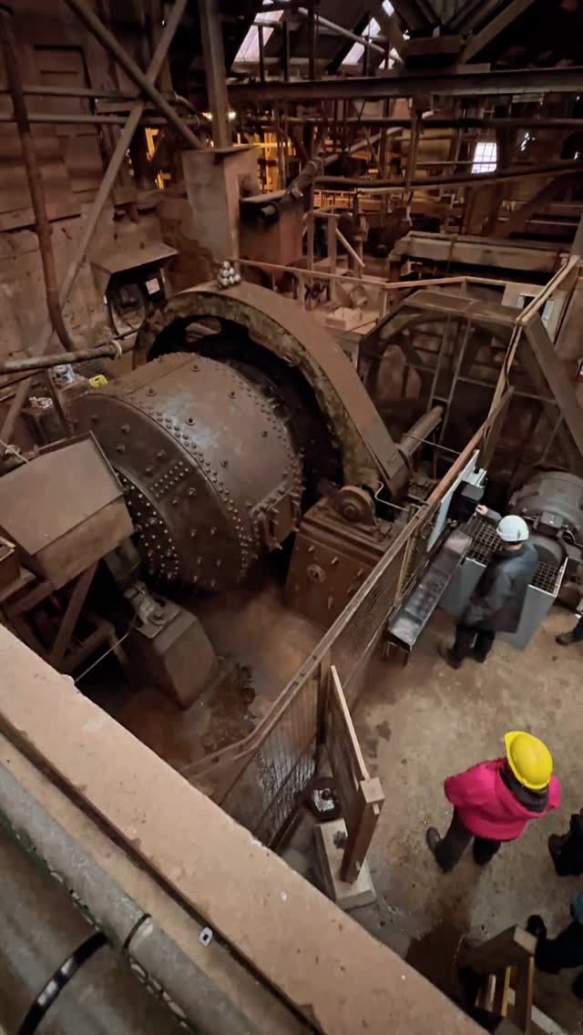 The 7 ft Hardinge Ball Mill at Geevor Tin Mine.
This machine is getting on 90 years old, but amazingly it still works! It’s amazing to see, although a lot quieter than it would have been when it was in operation.
Here’s some information from Geevor as to what its purpose was:
“The cassiterite occurred as very small grains within the ore. Finely grinding the ore liberated these grains from the enveloping rock and other minerals.
“The traditional method of grinding ore was to use stamps’ (a mechanical mortar and pestle). At Geevor there were originally eight Holman pneumatic stamps.
“During the early 1930’s small Hardinge ball mills were introduced to further grind the ore and improve cassiterite recovery. In 1937 the stamps were replaced by the present, more efficient, 7ft x 36in Hardinge conical ball mill.
“Ball mills work by tumbling the ore with heavy steel balls. As the mill rotated the balls broke down the ore by pressure, friction and impact.
“A flow of water washed the ore into the mill via the hollow feed trunnion, where it was ground to sand. The sand sized product passed out of the mill via the discharge trunnion to a screen (sieve).
“Any particles of sand which were still too large went back to the mill for further grinding. In this way the size of the ore particles could be controlled.”
A larger, 2.2 m-diameter Newell Dunsford Mill was later installed to increase capacity of the Mill at Geevor. Unfortunately, this was sold when the mine closed to a lead-zinc mine in Ireland.
@geevor_museum
#geevor #geevortinmine #geevortinminemuseum #tinmine #cornishmining #cornishmines #penwith #cornwall #cornwallcoast #cornishcoast #walkingcornwall #explorecornwall #lovecornwall #cornwallgeology #cornishgeology #geology #geologyrocks #geolife #geologist #geologistsofinstagram #learninggeology #geoadventure #exploregeology #geologicalwonders #amazingcornwall #mining #visitcornwall #geologylife #geologyfieldtrip #cornwalllife