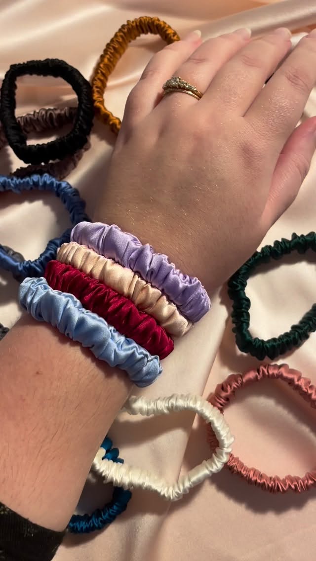 If you are still putting up with flimsy hair elastics that tug and pull your hair, this is your sign to treat yourself to a strong, silk covered hair elastic upgrade in 2026!
These are available in 29 colours and prints and both individually and in value sets where you can pick your own colours (I don’t believe in those pre-decided colours in sets where you end up with at least one colour you aren’t really fussed by!)
But that isn’t all there is to love about these! Each silk hair tie is made in small batches in the UK with a hand stitched finish. And because they are all made in house, if you want a little less elastic or a bit more to get the perfect fit for your ponytail, just get in touch and I’ll get sewing!
Video description- Jo’s wrist has four silk hair elastics in pale purple, pale pink, deep red and pale blue on against a background with more silk hair elastics in various colours. Jo takes off the pale purple silk hair elastic and stretches it vigorously and then stretches another hair elastic in a coral colour while audio says “no, no, no, no because this right here. 10 out of 10. 10 out of 10. I’m obsessed.”