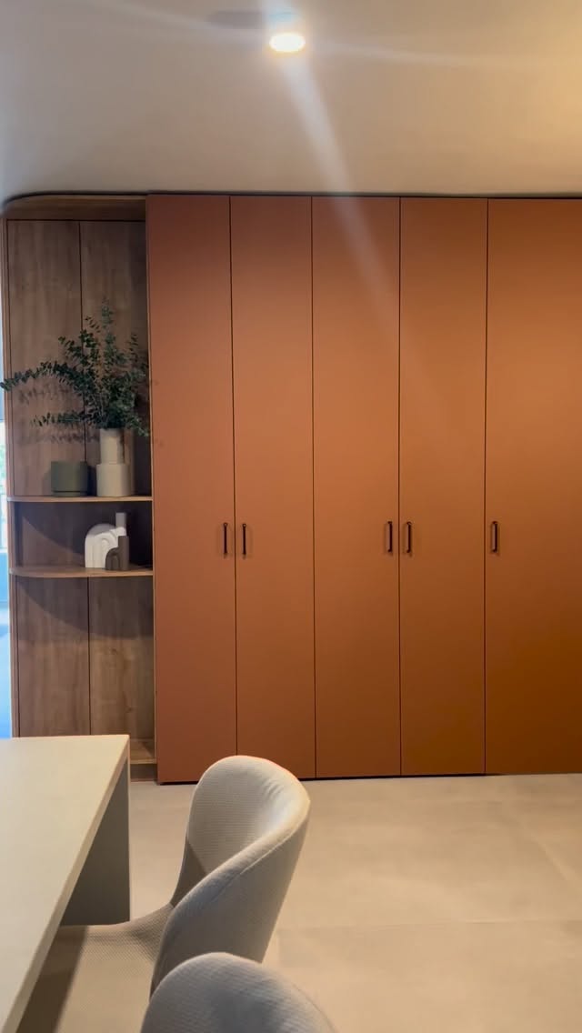  שילוב בין עץ טבעי וגווני אדמה בנגרות כניסה.
בתכנון פרטי נגרות גדולי ממדים, הממוקמים באזורים מרכזיים כמו מבואת הכניסה, הבחירה החומרית היא זו שמכריעה אם היחידה תכביד על החלל או תגדיר אותו מחדש.
בפרויקט ברמה״ש, הנגרות משמשת כאלמנט פיסולי המפריד בין הכניסה לחלל הציבורי, תוך שימוש בניגודיות חכמה בין חומרים.
הבחירה בגוון טרקוטה עמוק (מסקלת ה-Salmon/Pink) עבור חזיתות הארון נועדה לייצר “כתם צבע” דומיננטי אך חמים, המשתלב עם הריצוף האפור ושובר את המונוכרומטיות של החלל. גוון זה נבחר בקפידה כדי להעניק נוכחות מבלי להשתלט יתר על המידה.
כקונטרה למסות הצבע האטומות, שולב אלמנט פינתי פתוח בחיפוי אלון במראה טבעי. סיום הנגרות בפינה מעוגלת ומדפים פתוחים מרכך את המעבר מהכניסה אל הסלון, ומאפשר תצוגת דקורציה שמוסיפה רובד אישי ואוורירי ליחידה המסיבית.
ההחלטה העיצובית להשתמש בחזיתות חלקות עם ידיות מינימליסטיות שחורות אינה מקרית. היא נועדה להסוות את המורכבות הטכנית שמסתתרת מאחורי הדלתות – החל מדלת הממ”ד הנגררת שנכנסת לתוך גב הנגרות, ועד לארונות החשמל והתקשורת.
הצבע והחומר הופכים את האילוץ הטכני לאלמנט עיצובי בבית.
צלמת : אורית ארנון | קבלן : ערן לוזון | סטיילינג ליום צילומים : יעל גאון | נגרות : נגרית בוטיק לולה | ידיות : חבושה
#מעצבתפניםבשרון #מעצבתפניםבמרכז #נגרות_בהתאמה_אישית #נגרותבהתאמהאישית #נגרות_מקצועית