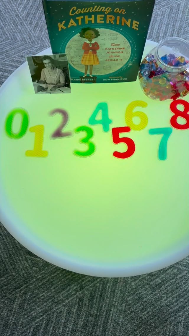 Inspiring Young Mathematicians Through Play for Black History Month //During #BlackHistoryMonth, learning about Katherine Johnson, an extraordinary mathematician whose love of numbers helped change history & send astronauts safely into space at NASA during a time when both women & Black Americans faced unfair barriers in science & education; her courage, determination, & brilliant thinking remind children that they can dream big & make a difference, & the book Counting on Katherine: How Katherine Johnson Saved Apollo 13 bringsher inspiring journey to life by sharing how she grew up, followed her passion for math, became a teacher, & later used her incredible skills to support historic space missions.
After reading the story to better understand her life, her impact, & why her story still matters today. This developmentally appropriate & engaging invitation was way a for children to explore numbers & one-to-one correspondence using loose parts. @discountschoolsupply sensory numbers & gems were placed out on the light table the children to explore, sort, & count as they played.
In the early years, children learn best when they can touch, move, & explore. Hands-on experiences help children make stronger connections between what they see and do, so they are building real understanding, not just memorizing numbers. This kind of playful learning helps make math feel familiar, comfortable, & enjoyable.
As children develop number sense, they move through 2 key stages of counting: rote counting & one-to-one correspondence. Rote counting is reciting numbers in order, while one-to-one correspondence is matching one number to one object. This 2nd stage is important because it helps children understand that numbers represent real amounts.
Open-ended, hands-on activities support this learning by helping children connect number symbols, spoken numbers, & real objects. As children count & place items, they build accuracy, focus, & confidence, & begin to see math as something they can explore & understand. #tinkerwonderplay #earlymathskills #loosepartsplay #lighttableplay