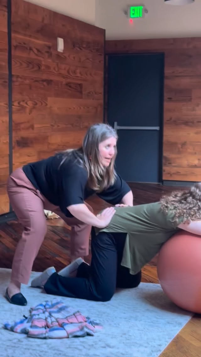 Kristie Graybill demonstrate the double hip squeeze technique for birth partners. She explains how to position your hands on the meaty part of the hips and apply steady pressure during contractions, holding for the full length of the contraction without pulsing. We discuss how to know when the contraction ends and when to release the pressure. Learn more at our childbirth education classes.