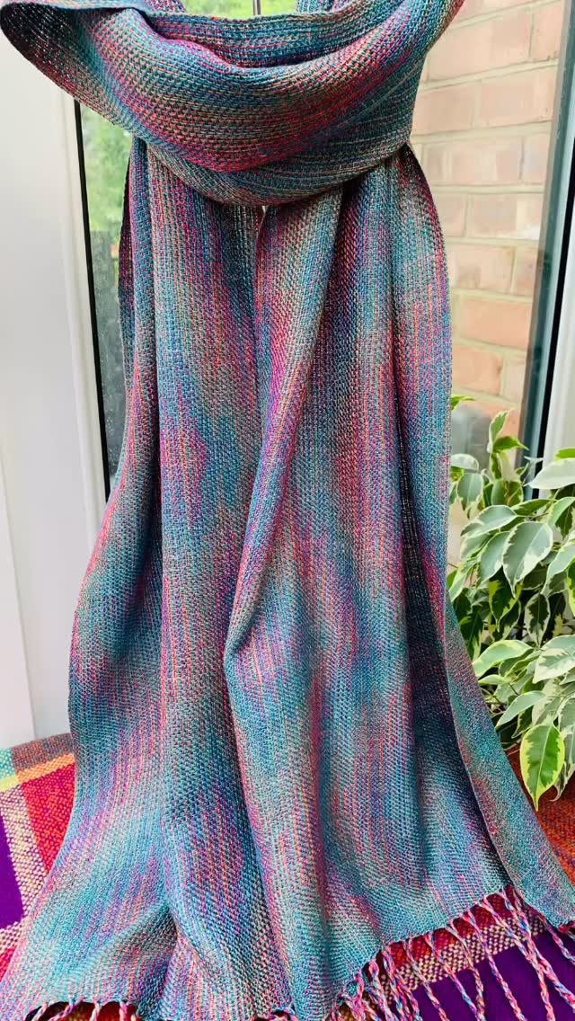 From threads of four colours, an echo emerged…
now softened by water, bloom, and touch.
This silk scarf has finally been wet finished — the weave settling into itself, the colours deepening and dancing together in new ways. Every fringe has been hand twisted, one by one, a quiet ritual to complete the cloth.
I love how the echoweave structure catches the light differently with every fold — flashes of turquoise, ember red, deep ocean blue, and coral appearing and disappearing like memory.
A scarf woven slowly, finished patiently, and ready at last to be worn into the world. ✨
I’m at Studio 92 on the @south_farnham_artists_trail for @surreyartistopenstudios this June.#farnhamcrafttown #handweaving #creatorsoflouet #luxuryaccessories