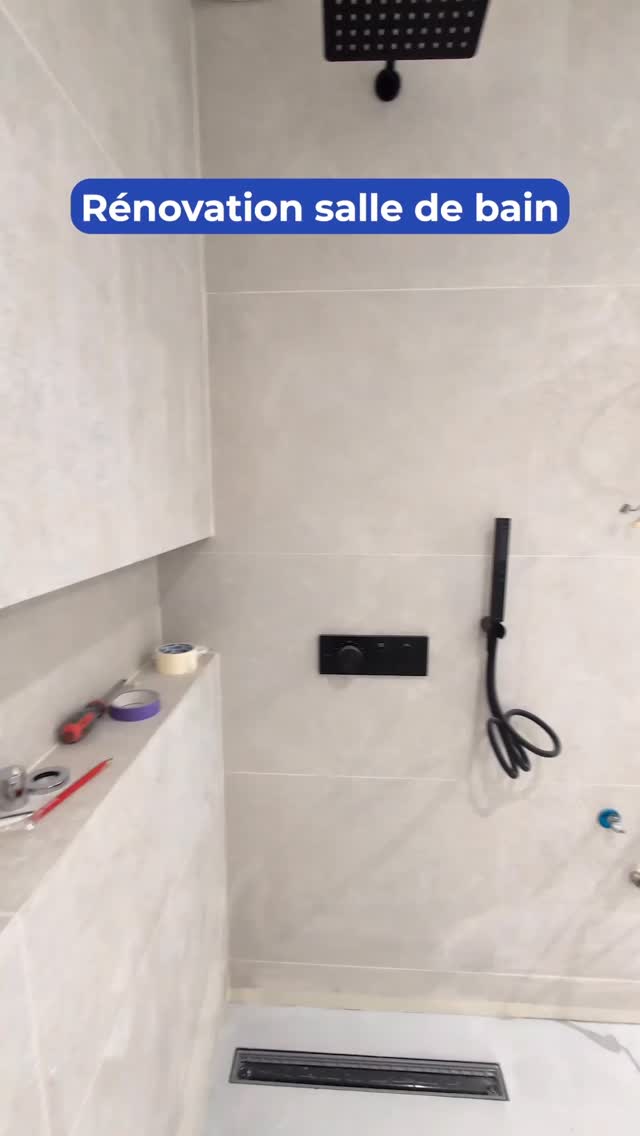 Salle de bain contemporaine avec revêtement effet béton ciré, robinetterie encastrée noire et finitions soignées. Une réalisation élégante pensée dans les moindres détails pour un rendu moderne et intemporel.