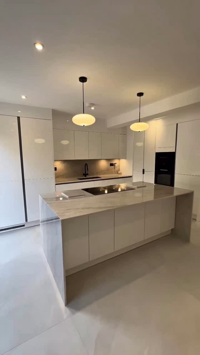 Minimalist design meets natural masterpiece. ✨ There is something so timeless about pairing crisp, white gloss handleless cabinets with the soft, flowing veins of Taj Mahal quartz. Clean lines, warm undertones, and pure luxury. #KitchenDesign #ModernKitchen #HandlelessKitchen #InteriorInspiration #interiordesign