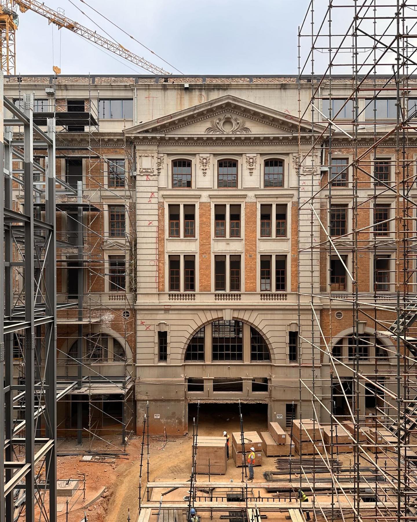 We are excited to share some site progress pictures of our adaptive re-use project for the historic Transnet SOC Head Office building at 96 Rissik Street, Johannesburg. The design honours the building’s heritage while revitalising the internal spaces in line within contemporary workplace trends. The Northern wing of the building dates back to 1905, while the (final) Southern wing was completed in 1938. This project involved the demolition of an insensitive concrete car park and lift structure erected in the 1950’s, in order to create a new covered atrium, which serves as the focal point of the building’s design. This includes a new roof made up of lightweight ETFE panels supported by a custom-designed steel structure. Additionally, a new vertical circulation core is being constructed, including glazed lifts; and open-sided walkways and stairs to facilitate access to and between various departments throughout the building.
A notable development during the past week is the arrival of the 23,7m high steel columns, which are integral to the courtyard design.
#Architecture #Heritage #OsmondLange #Transnet #Johannesburg #ConstructionProgress