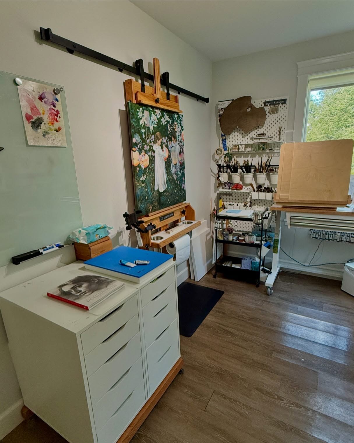 Studio update. I don’t have a very big studio. My easel is wonderful & a gift from my dad. It’s solid oak and can accomodate large canvases but took up two + feet of depth. I saw this idea from @artandangling and had extra barn door hardware sitting in my garage. I am so thrilled to gain so much space. And It’s still fully adjustable. I can put very large paintings on it. I had casters on the bottom of the easel previously and didn’t want to just store it. So I saw that my two Ikea Alex drawers fit perfectly on top. Now I can roll that around. I can also add my smaller easel to the side on the rail because that was a gift from my dad too. I just wish I could share it with him. Someday soon!