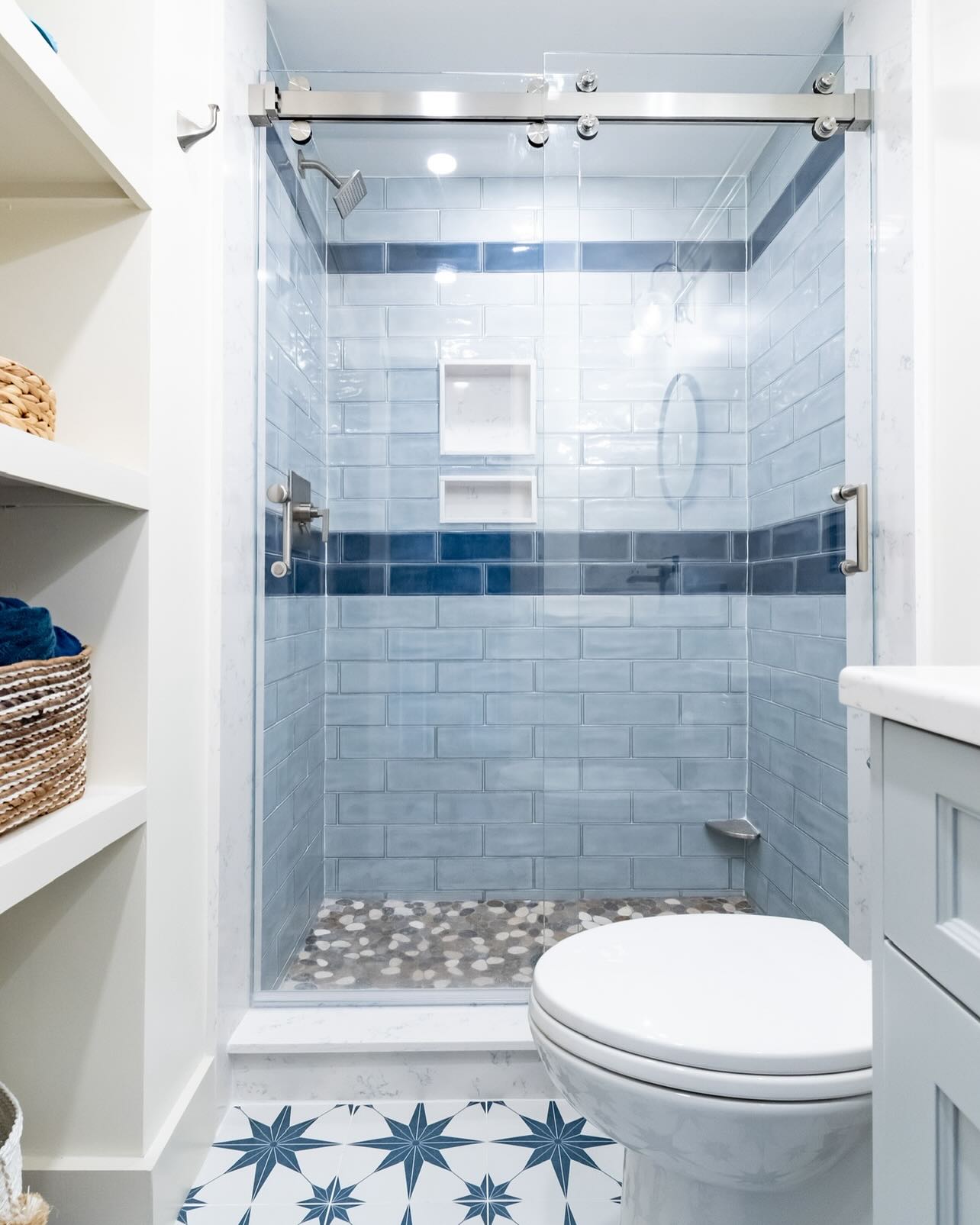✨ A bright and breezy bathroom with personality! ✨
The soft blue subway tiles and bold navy accent stripe in the shower create a calming vibe, perfectly paired with the organic texture of the pebble floor. But let’s talk about that floor! The starburst-patterned tiles bring a playful yet sophisticated energy to the space.
Smart storage, clean lines, and thoughtful details make this design both functional and stunning. Proof that small spaces can make a big statement!
What’s your favorite detail? Let us know below! ⬇️
#BathroomDesign #TileInspo #LuxuryBathrooms #CustomHomes #EchelonBuilders #InteriorDesign #SubwayTile #StarburstTile #DesignDetails #Echelon