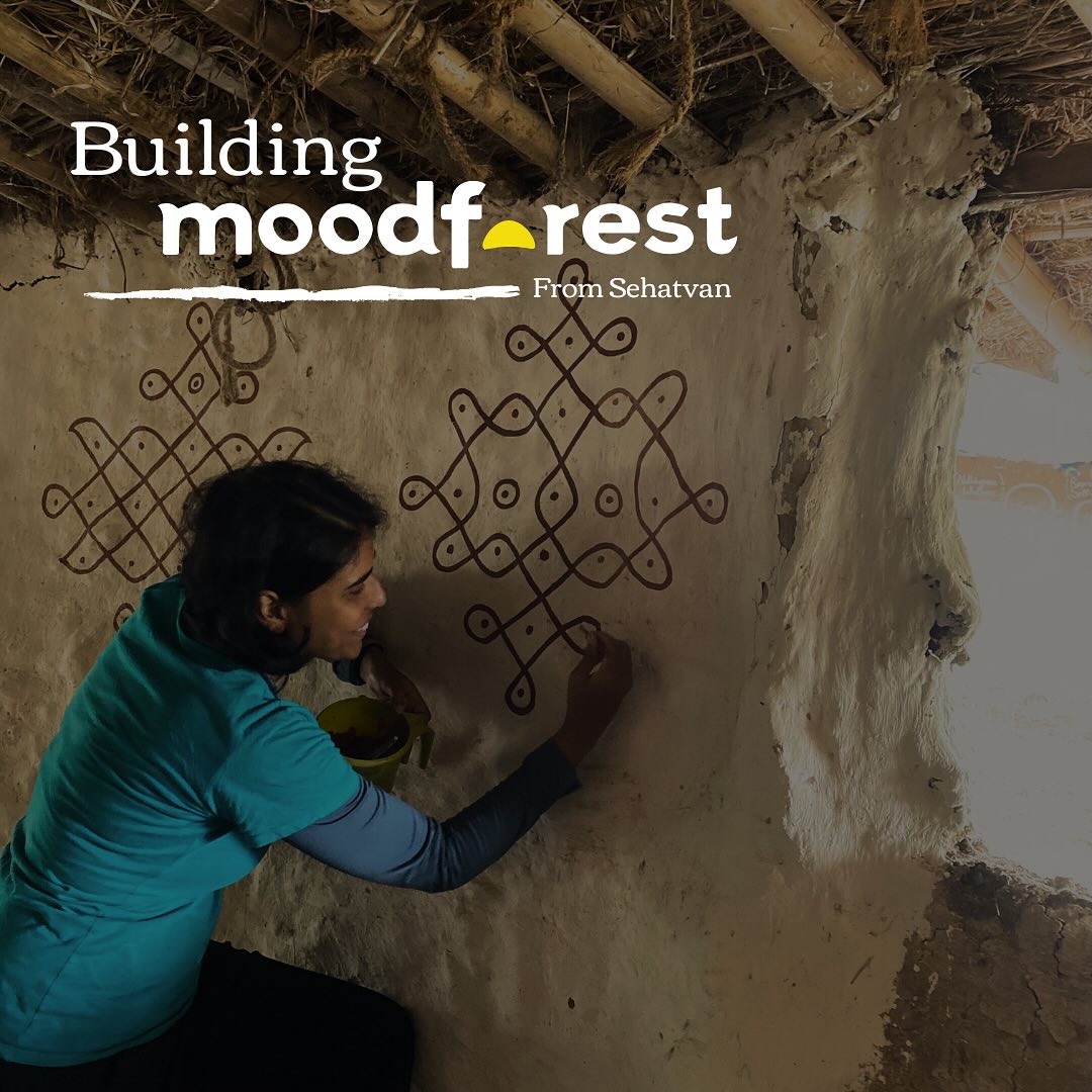 In the beginning, our living room was a wandering concept. Some days we’d eat in the kitchen, other times under a tree when the weather was kind. One summer, we even created an entire outdoor space. But eventually, we found our permanent solution – this cute living room that became the heart of Moodforest.
This was basically Vipin’s playground – and calling it an ‘art project’ might be the most accurate description. Imagine creating an entire space without a single measuring tape, just pure instinct and a whole lot of creative madness. That’s how our chief architect rolls. If these walls could talk, they’d tell stories of endless chit-chats, post dinner card games, and meals that turned into memories. And here’s the fun part: almost everyone who’s visited has left a little piece of themselves here. Lipai – the traditional floor making technique – in this room is a communal ritual during our camps.
We hosted Shwetha and Nikhil, who visited us last December with their adorable daughter and Shwetha ended up painting these beautiful kolam designs which are still here, dancing on our walls!
#buildingmoodforest #foresttherapy #wellness #biohappiness #moodforest #sehatvan #nature #naturetherapy #forestbathing #health #happiness