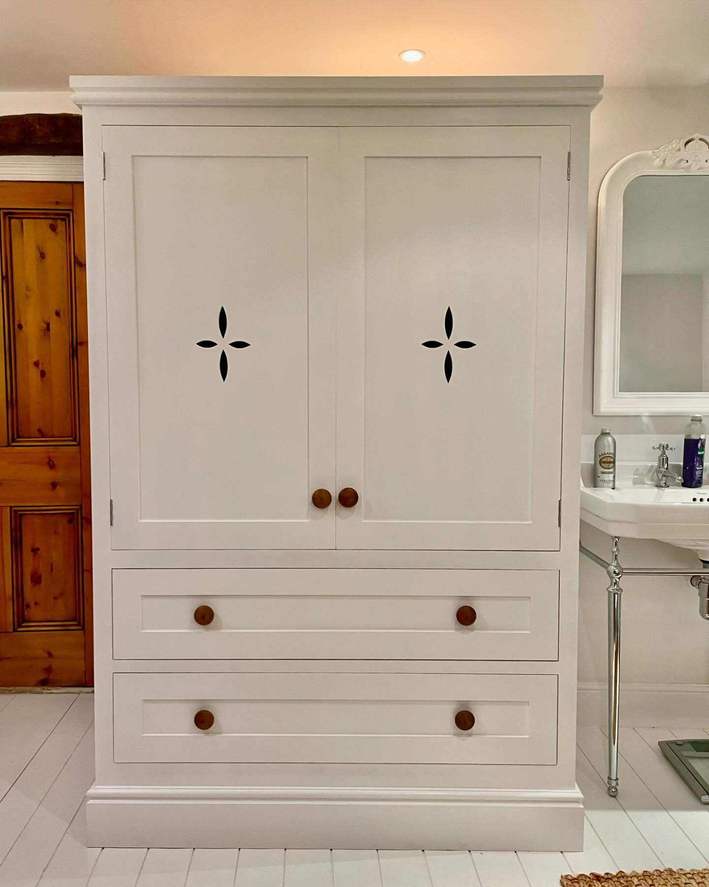 Large double door cupboards are perfect for any room, in a kitchen for a larder cupboard, in a bathroom as a linen cupboard or even in a bedroom as a wardrobe. They are endlessly practical and beautiful too. This one is sitting pretty in a bathroom, with its petal cut-outs and in the perfect subtle white. #jharriskitchens