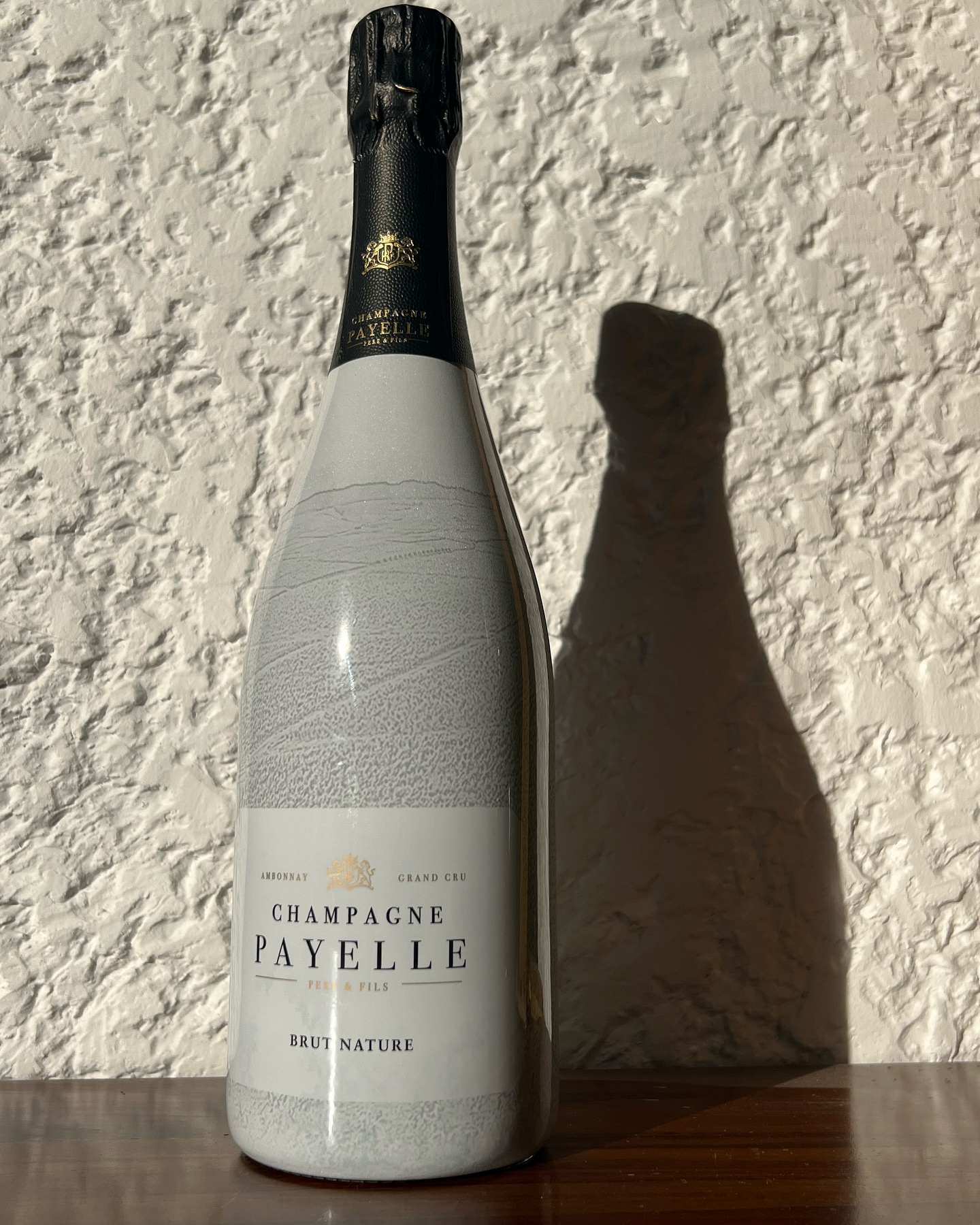 BRUT NATURE, Pour célébrer la deuxième édition du BRUT NATURE, nous avons décidé de garder notre sleeve en le modifiant pour y ajouter le vignoble de la Montagne de Reims telle qu’elle se dévoile depuis Ambonnay. Nous y retrouvons certaines de nos parcelles, là où naissent nos raisins d’exception, cultivées par nos soins.
Le champagne de chaque bouteille de Brut Nature est donc très peu dosé, pour laisser s’exprimer le Pinot Noir, Cépage emblématique d’Ambonnay.