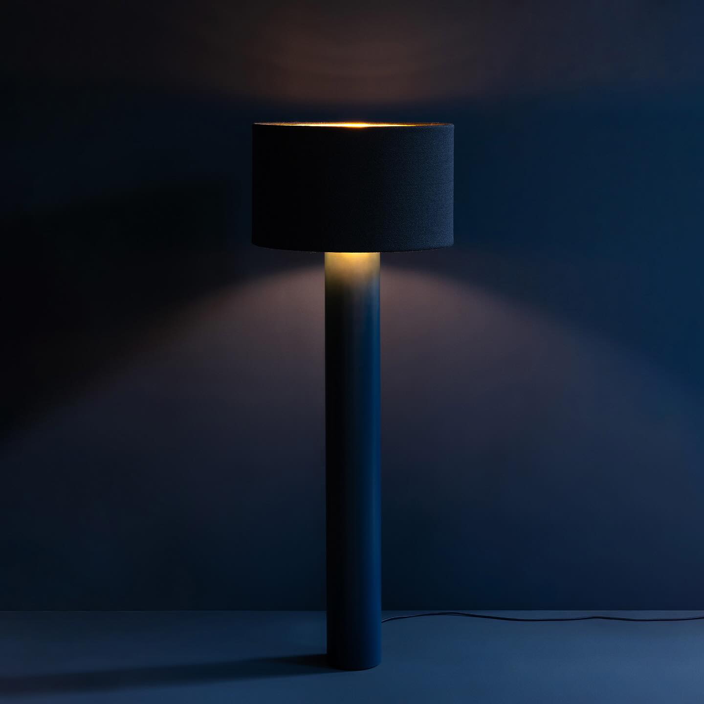 ALL ROUND TALL IN NAVY BLUE
The floor lamp features a seamless monochrome design, evoking the impression of being cast from a single mould. The lampshade is upholstered in wool bouclé Vidar 4 by Raf Simons for Kvadrat, complemented by a textile-lagged cable. The powder-coated steel base discreetly conceals a stabilising weight, ensuring both stability and a streamlined silhouette. Inside, the lampshade is lined with matte gold foil, softly reflecting light to create a warm and inviting ambiance.