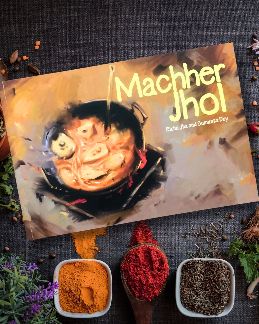 Machher Jhol
By Richa Jha
Illustrated by Sumanta Dey
One of the finest books we’ve read in a long time—deceptively simple yet richly evocative—Machher Jhol is nothing short of a masterpiece. At its heart is Gopu, a determined young boy who sets out alone, convinced that his ailing father needs his favorite fish curry to recover.
Undeterred, he navigates the bustling lanes of Calcutta, seemingly during Pujo, in search of the freshest ingredients. His journey leads him from the bustling market to his grandmother’s house, where he hopes to create the perfect dish. Initially, details like Gopu counting his steps may seem incidental, but as the story unfolds, they come together in a brilliantly unexpected way. In hindsight, what seemed trivial transforms into a moment of nail-biting suspense—leaving us marveling at how easily things could have gone awry.
While the story itself is beautifully simple, the book’s true magic lies in its illustrations. Sumanta Dey turns every page into a cinematic spectacle—not in a way that diminishes the power of books, but in a way that rivals the immersive grandeur of film. His artwork is anything but simple; it is intricate, evocative, and a pure joy to behold. More than just illustrations, they are a love letter to Calcutta, making us yearn for more from this incredibly talented artist—a loss that feels almost personal.
Books that celebrate food and culture always hold a special place, and Machher Jhol is a heartfelt ode to family, love, and the unifying power of food.
Ideal for children aged 5+ years.