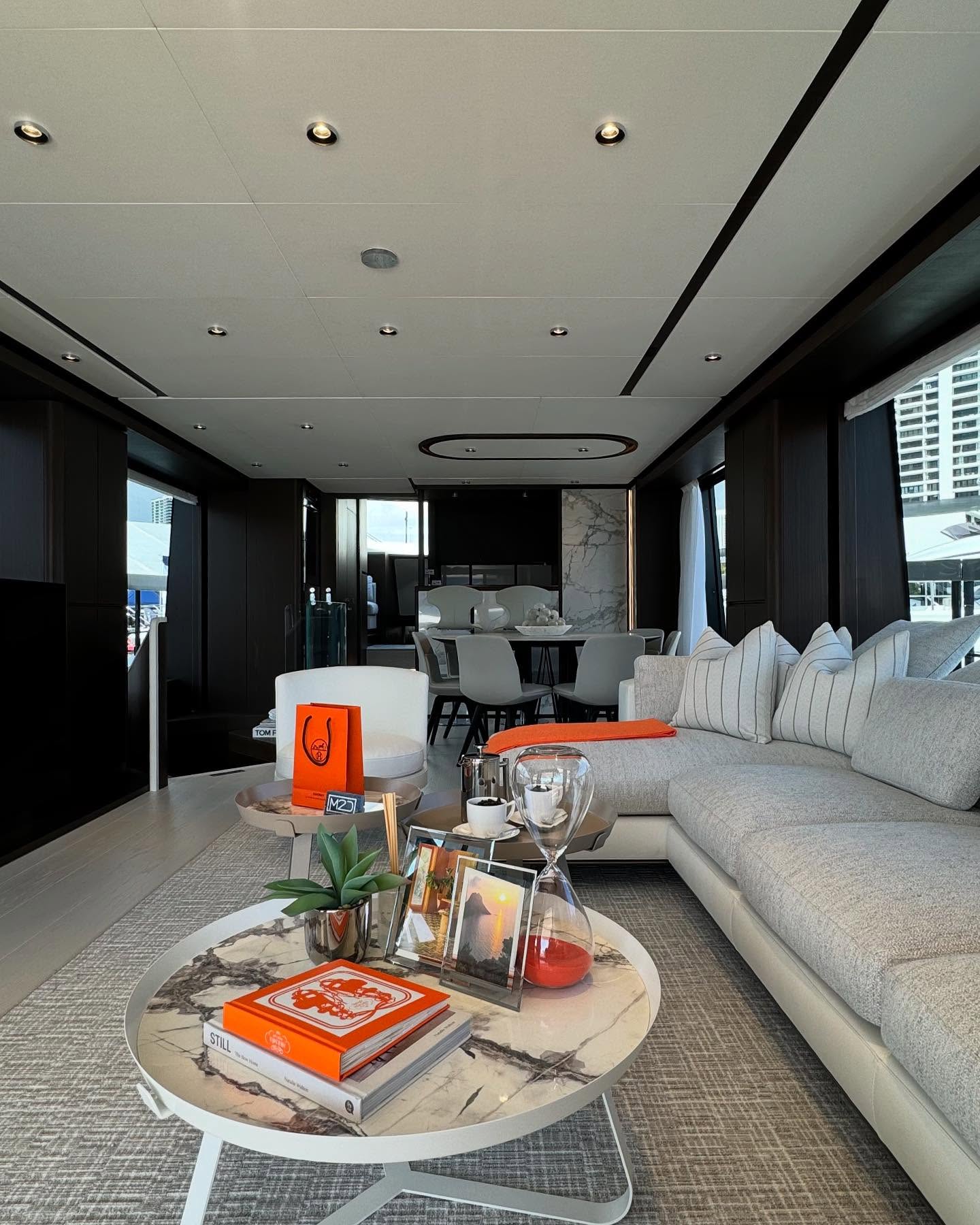 The interior of the Ferretti 860 blends the grounding presence of dark woods with the lightness of neutral tones, while the vibrant pop of orange serves as the perfect accent, creating a space that is both serene and lively, timeless and contemporary