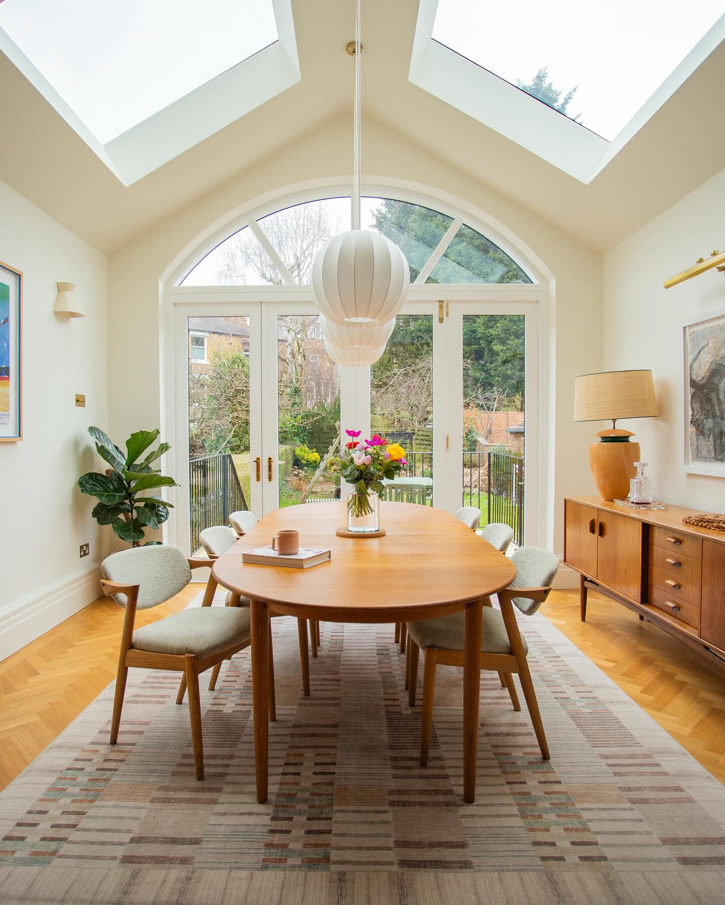 Honestly - this really is the same space! 🌞
When my clients said they wanted a better connection to the garden and the outdoors, I decided to go all out. The ceiling in what was the kitchen (swipe to see the before) was vaulted so we could add these huge frameless roof lights and we opened up the rear wall to make way for the stunning new arched bifold timber doors. These combined changes have given what was a rather dark room a real feeling of light and space. Almost like being inside an orangerie. When open, the dining area now leads onto a newly configured raised terrace area with steps down into the beautiful family garden below.
It’s truly a magical space!