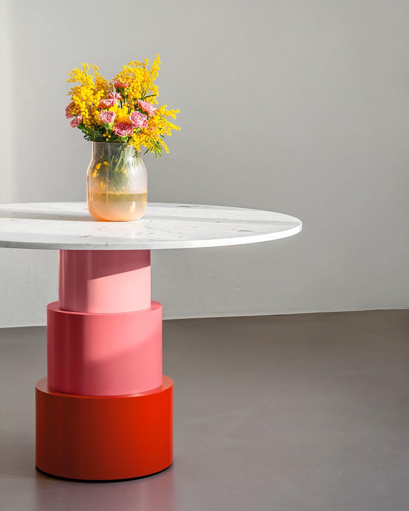 NEW U TURN TABLE
With its distinctive silhouette, democratic seating arrangement, and iconic colour scheme, U TURN serves as a striking centrepiece for any open space layout. The central base is made of three tapering cylindrical elements while the sleek tabletop made of Carrara marble appears to float above it.