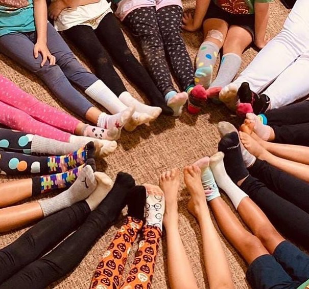 Todos os dias, uma criança chega com meias de pares trocados por aqui. Hoje, Yumi chegou! Rapidamente, entendemos que esse gesto fazia referência ao dia 21 de Março, data dedicada à visibilidade e à luta pelos direitos das pessoas com Síndrome de Down. Ao descobrirem o significado, outras crianças também passaram a trocar suas meias, num movimento espontâneo.
Na Escola da Árvore, todo dia é dia de celebrar a vida. Trabalhamos com a perspectiva da inclusão, e também do pertencimento. Cada momento é uma oportunidade de valorizar as individualidades, de escutar, de se implicar e de construir, junto com as crianças, um ambiente em que a diferença não apenas seja respeitada, mas reconhecida como potência.
Temos muitos pares com meias trocadas. Isso é o comum aqui, mas vamos marcar esse dia até que existam garantias de existência digna e respeitosa às pessoas com a trissomia do cromossomo 21, para além desta escola e de outras iniciativas isoladas.