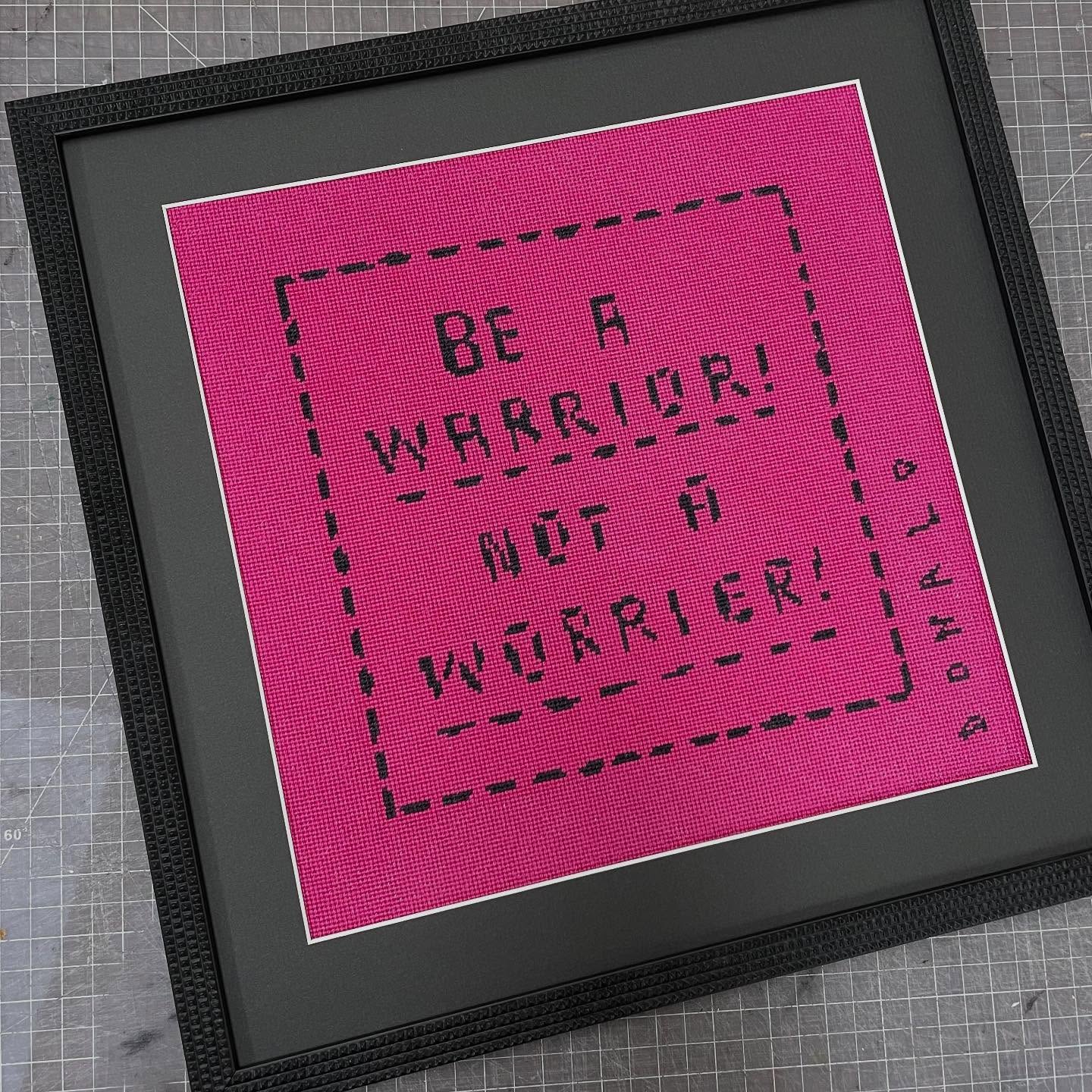 What we’re working on right now. Words to live by. #beawarriornotaworrier #fotiouframes #needlepoint #pink #customartframing