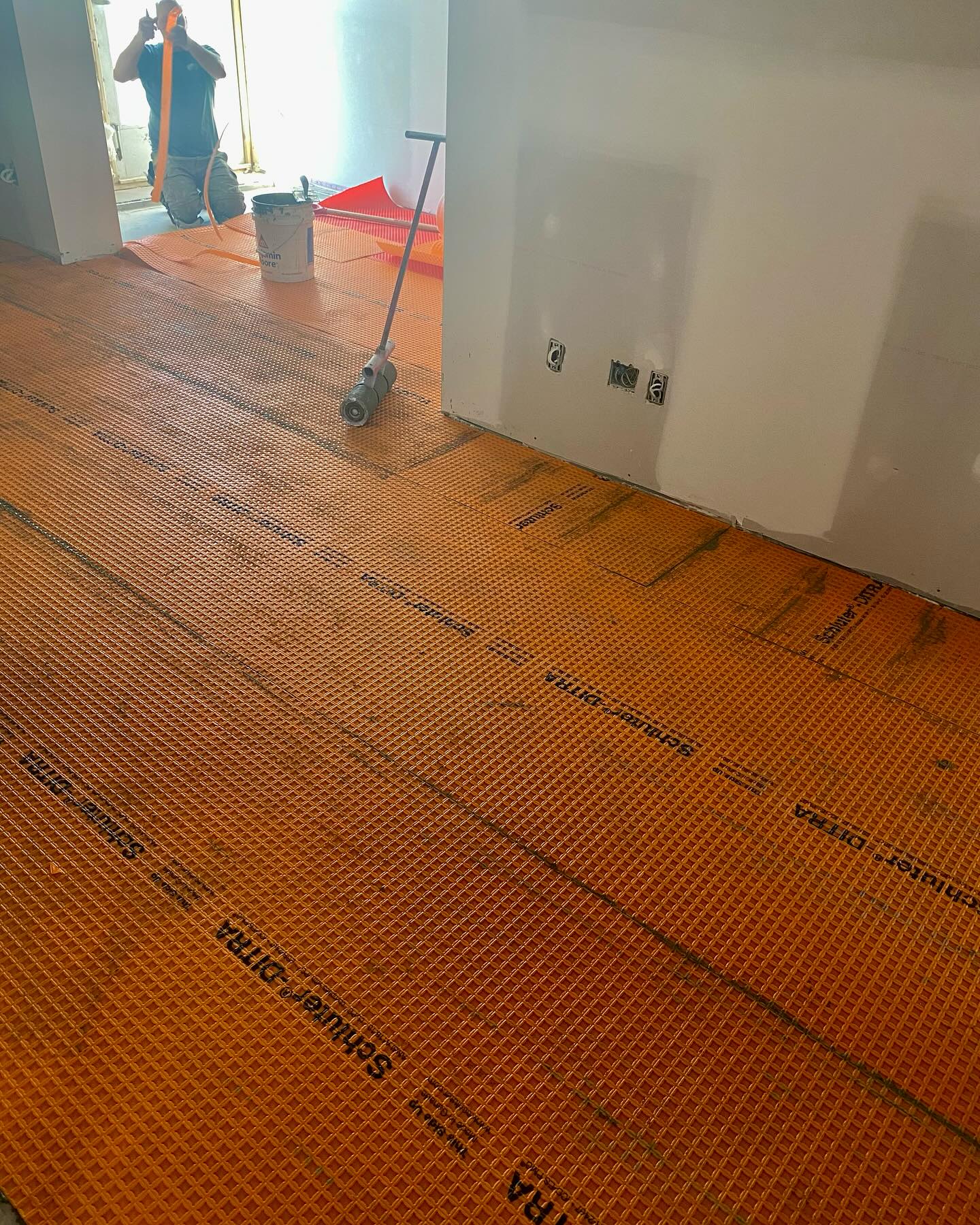 Les carreleurs installent la membrane Ditra avant la pose de la céramique. #constructionvcm #entrepreneurgeneral #commercial #carreleur #céramique