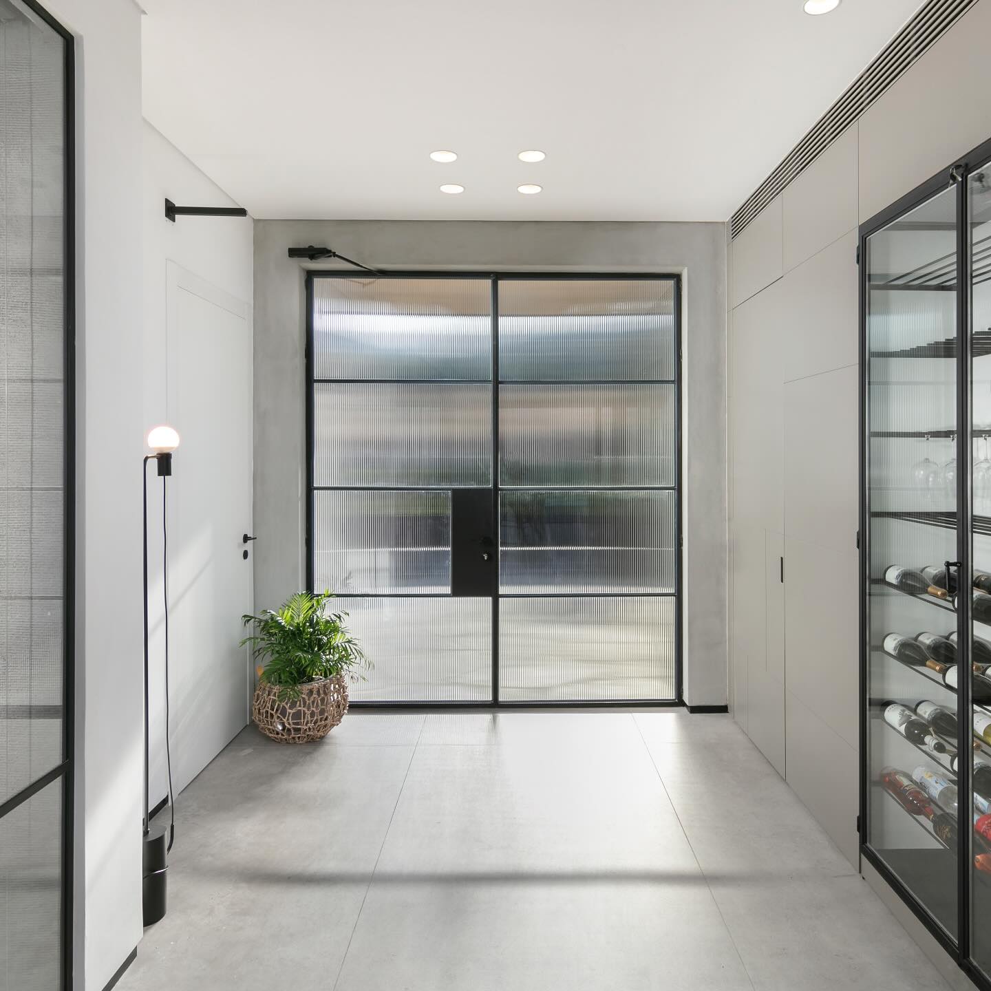 The semi-transparent entrance door brings in natural light while maintaining privacy